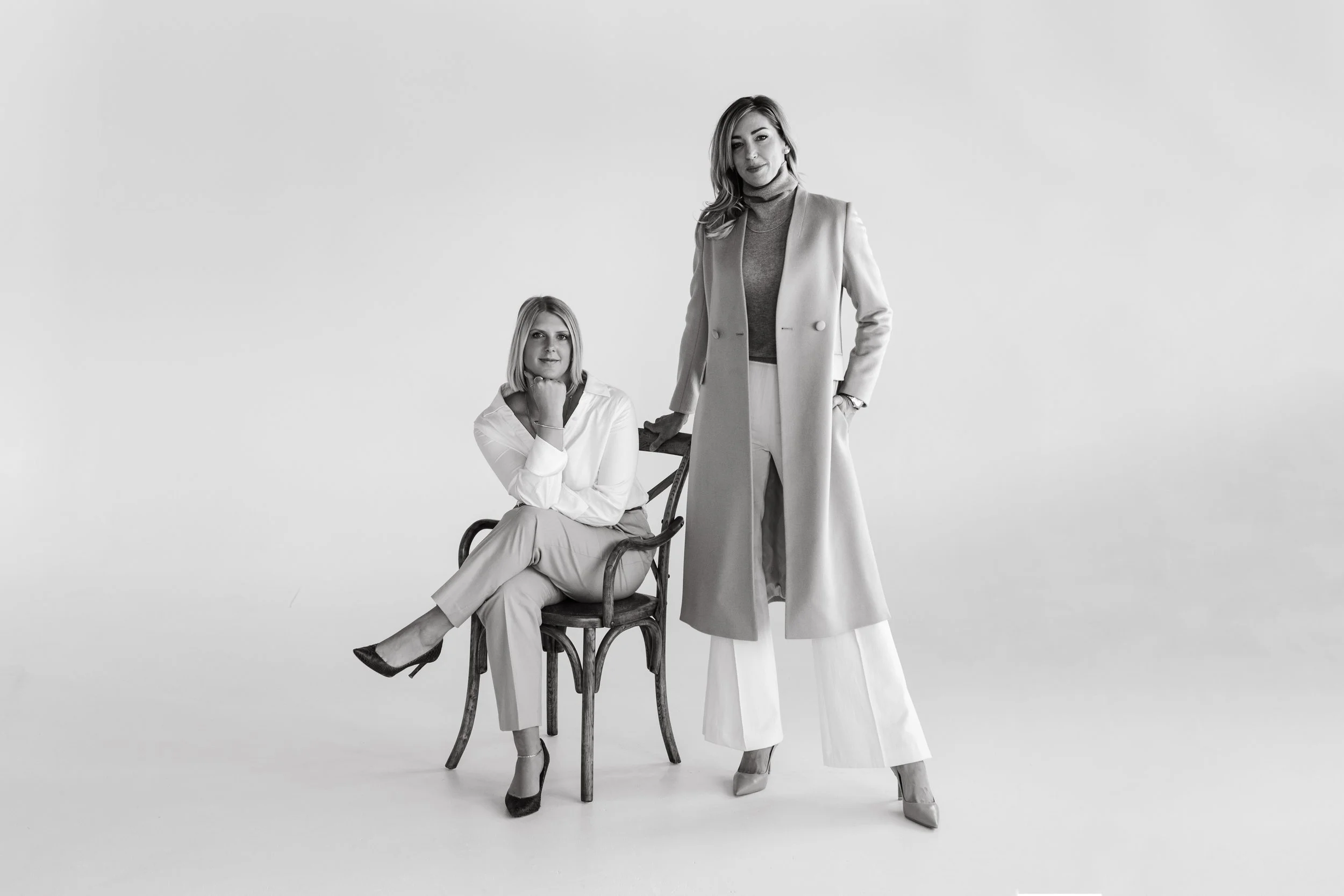 Two buyer's agents sit in studio for branding photo shoot.