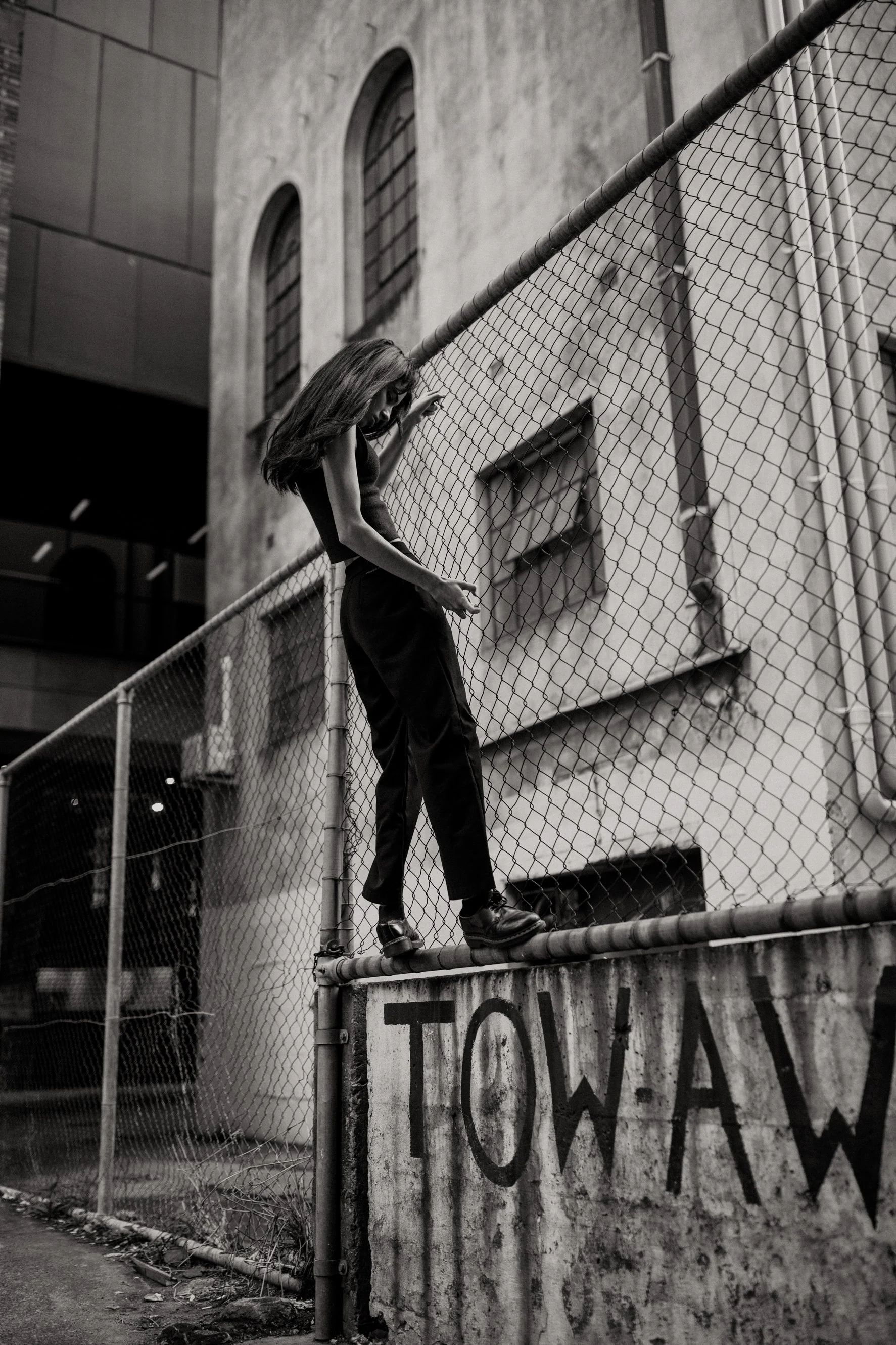 Brisbane artist climbs steel fence for photography session.