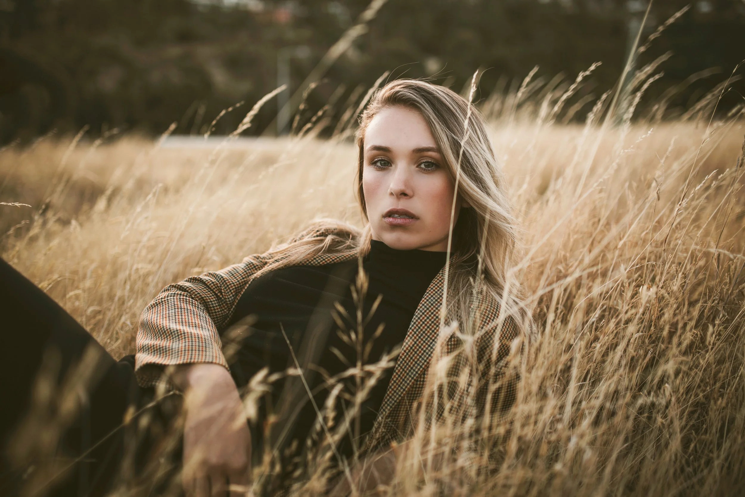 Woman relaxes in long grass for Tasmanian photo shoot.