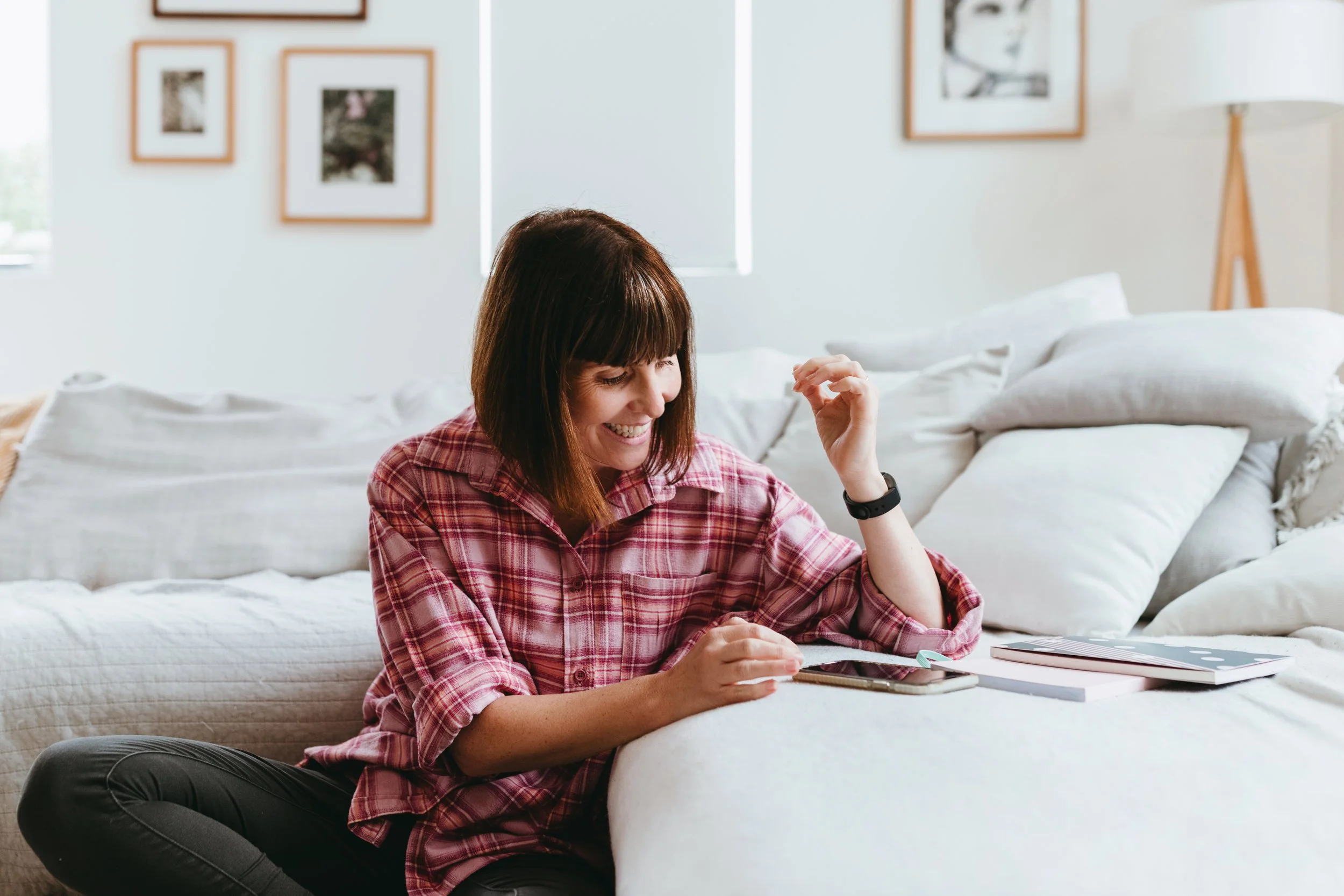 Woman smiles as she looks at her phone for photo shoot in Hobart.