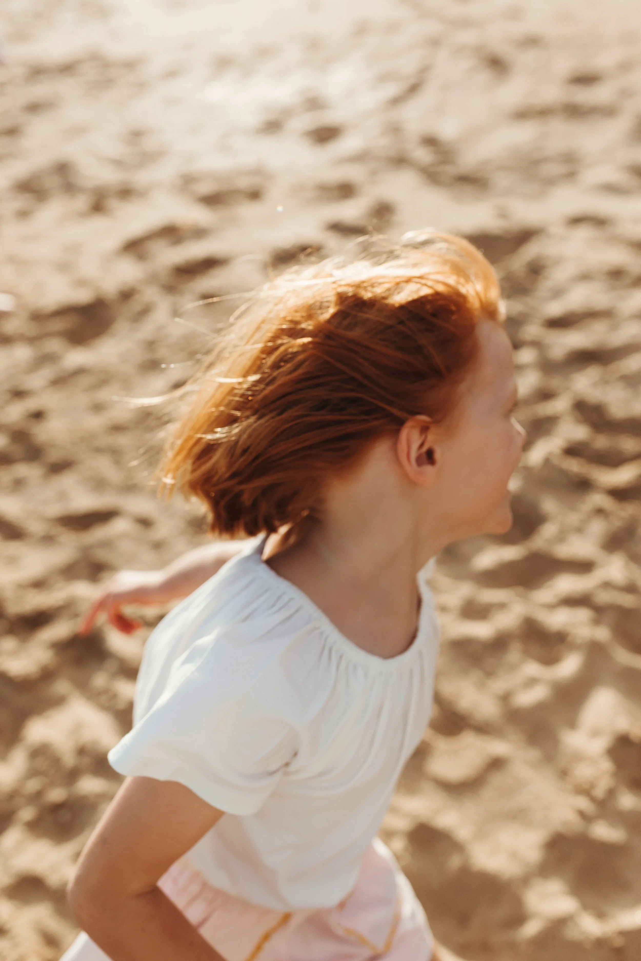 Young girl plays on the beach in Tasmania.