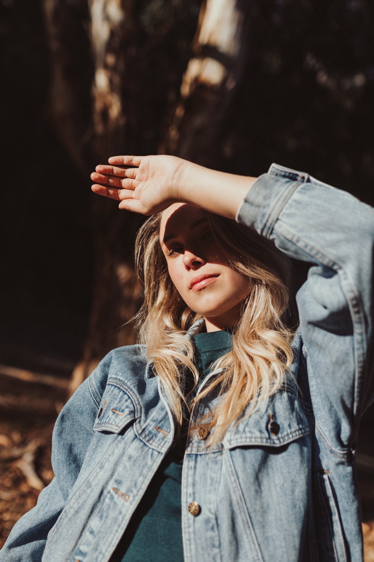 Model poses with hand shielding her eyes from sun.