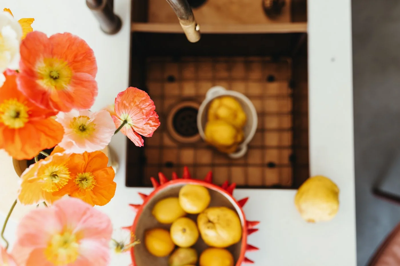 Birds eye view of quince and flowers around a sink for food writer's recipe book.