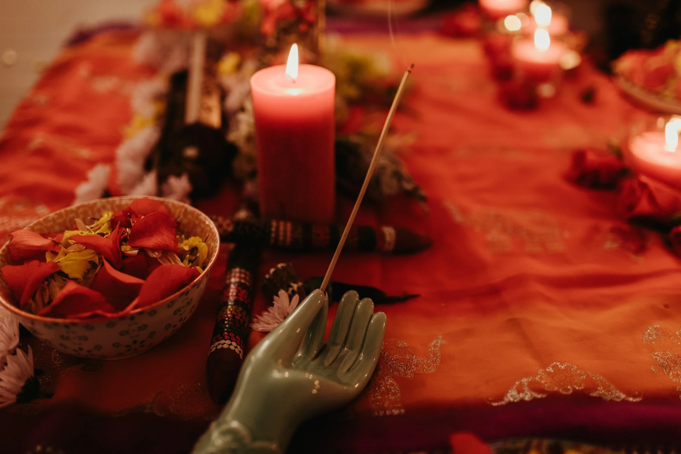 Close up photo of incense, flower petals and candles for event in Hobart.