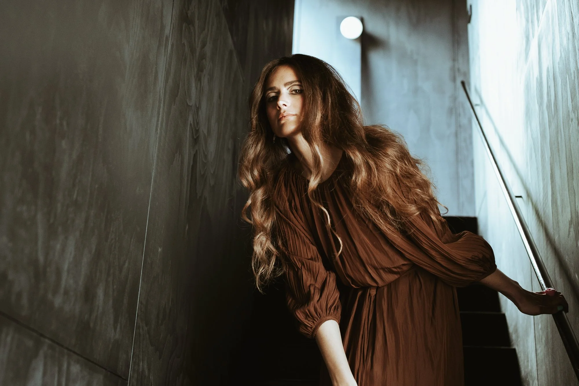 Woman poses in brown dress for fashion label shoot in Hobart, Tasmania.