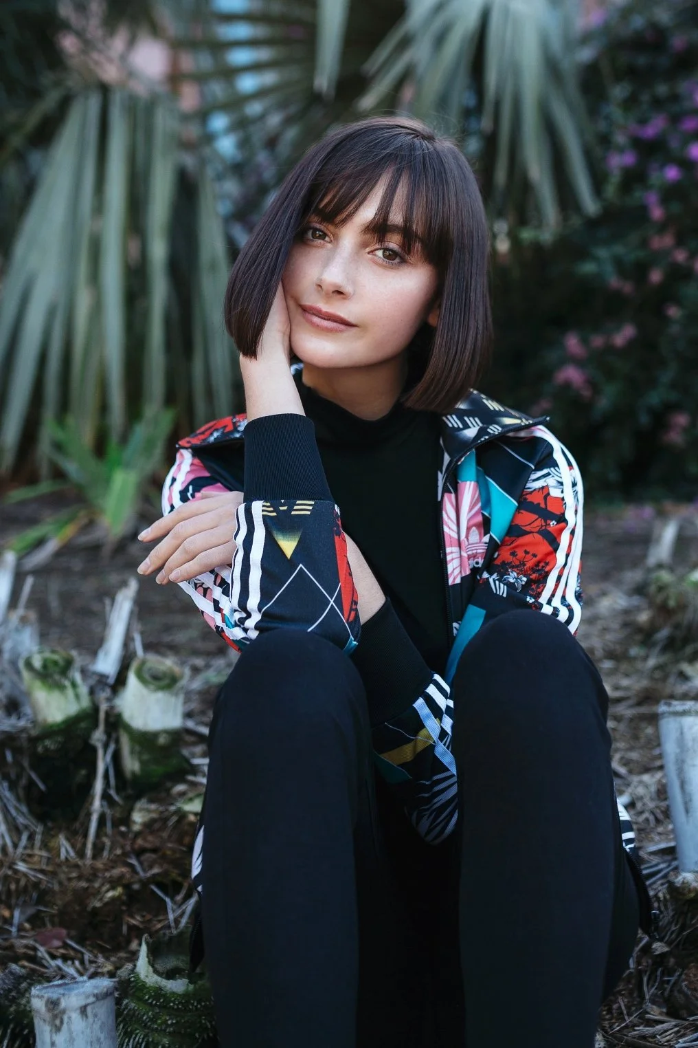 Model with bob hair cut sits in gardens of Brisbane.