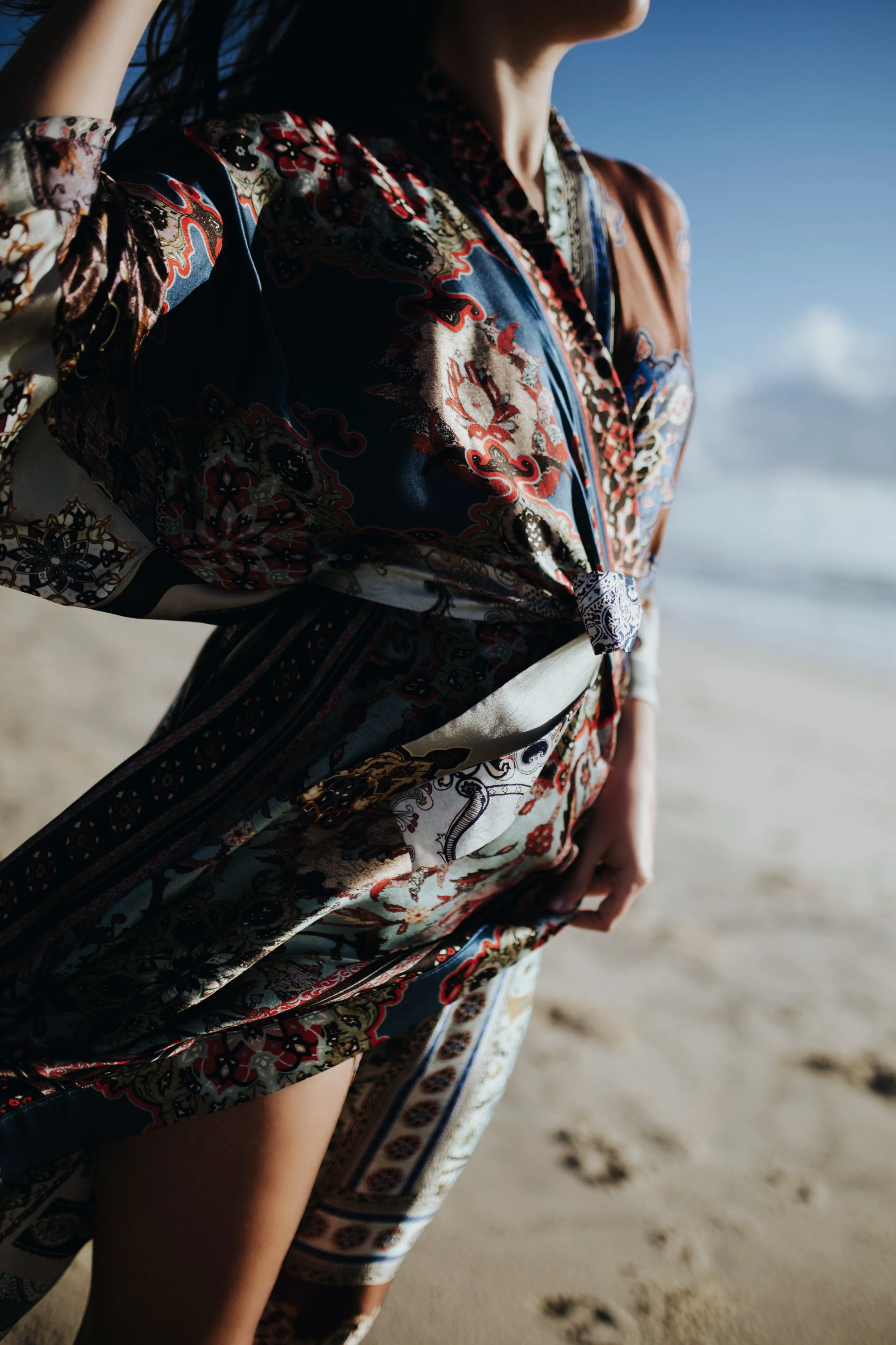 Silk kimono is blown by the wind at the beach on model.