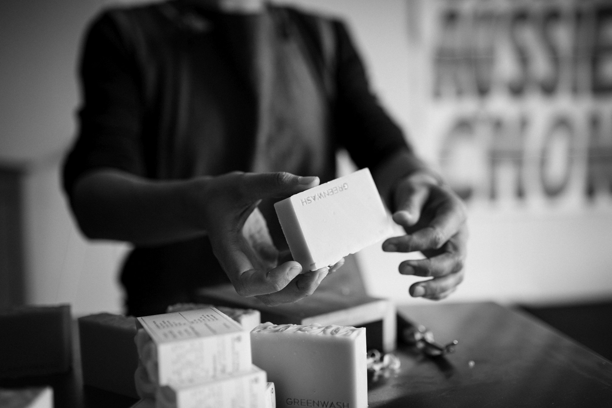 Soap maker holds soap during lifestyle branding photography session.
