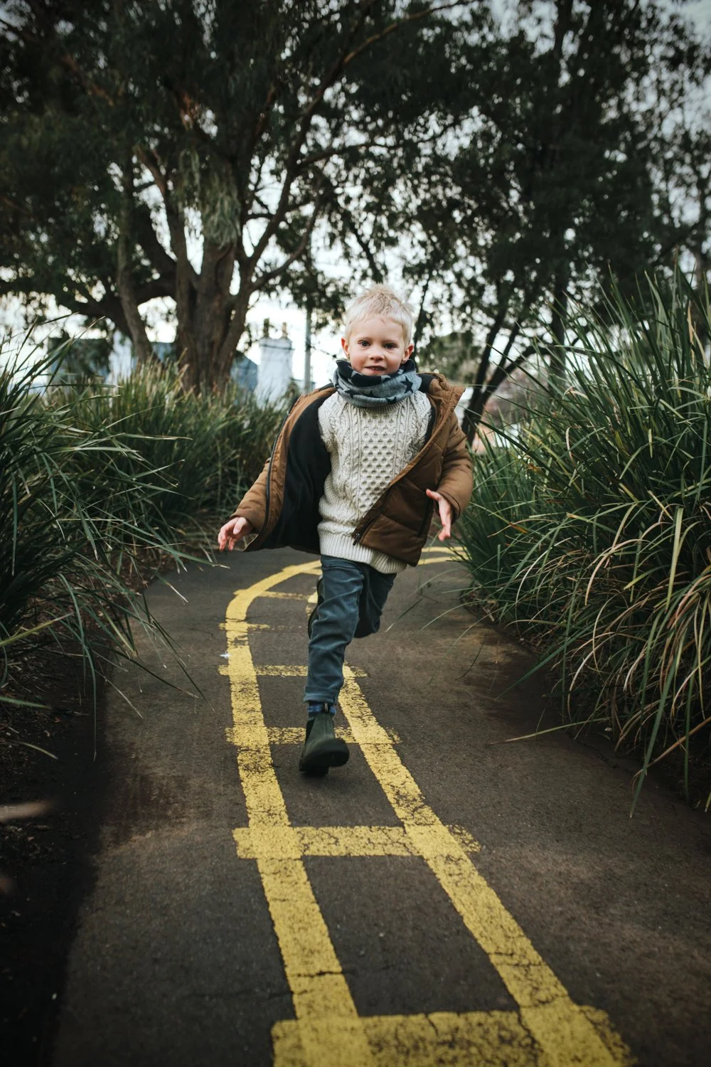 Blonde boy runs in playground for commercial shoot for Blundstone.