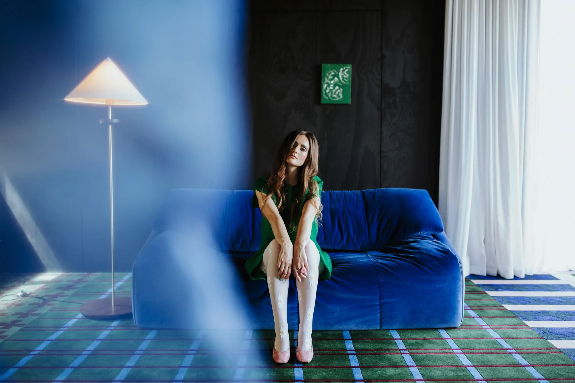 Woman poses on blue sofa for vintage photo shoot in West Hobart, Tasmania.