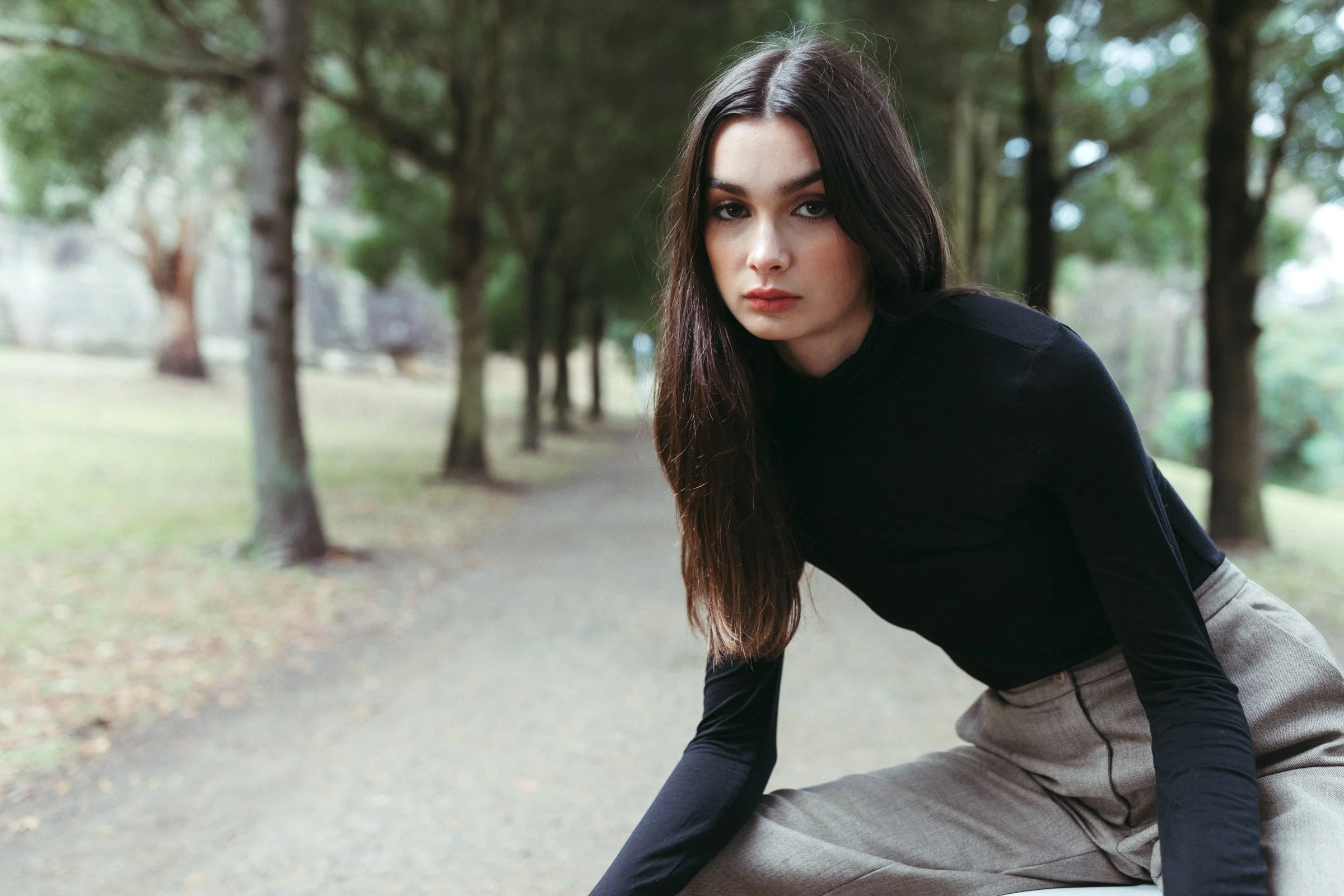Model poses in vintage Country Road fashion in park.