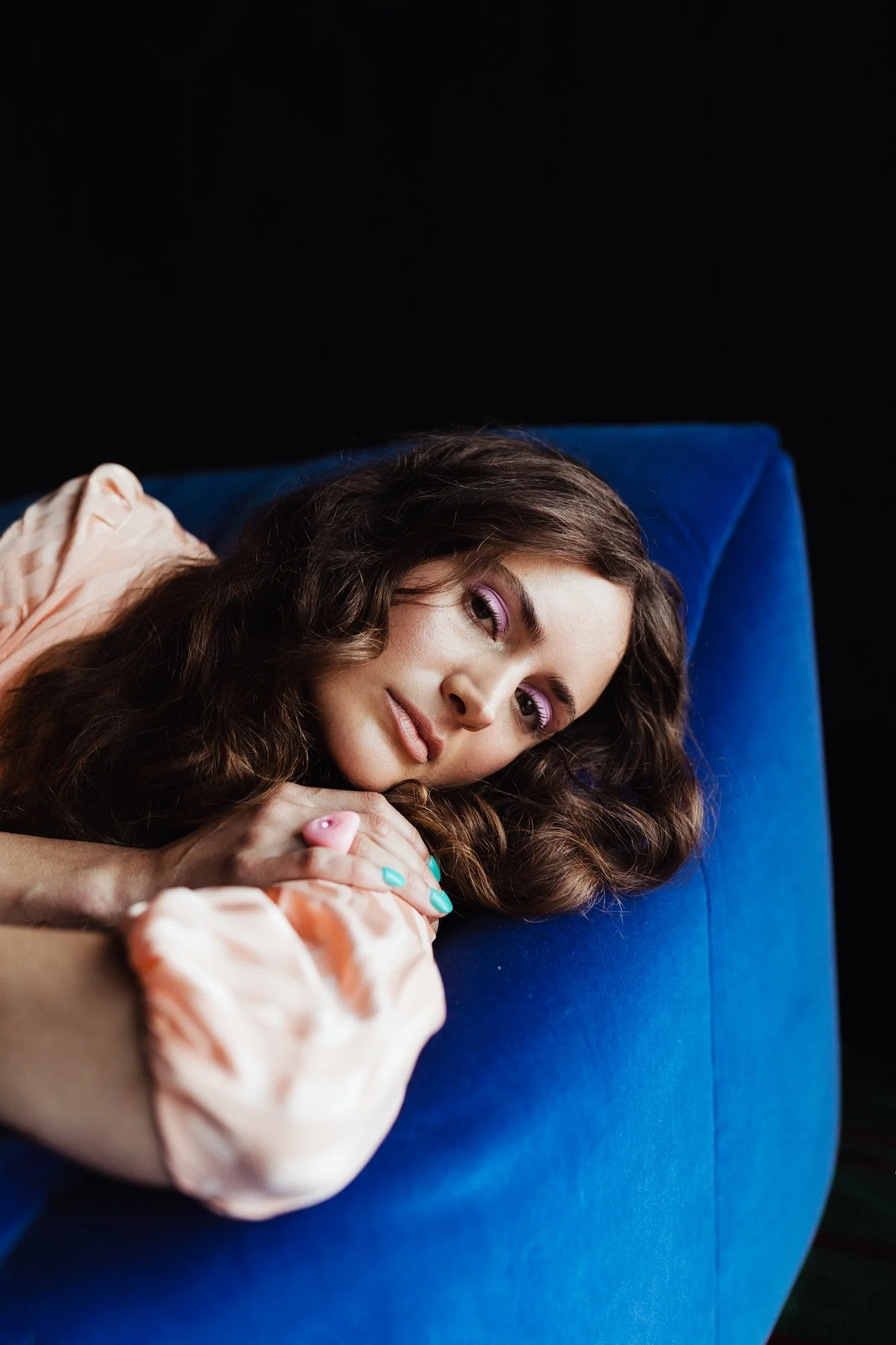 Lasca Dry lays on blue sofa for styled photo shoot in AirBnB.