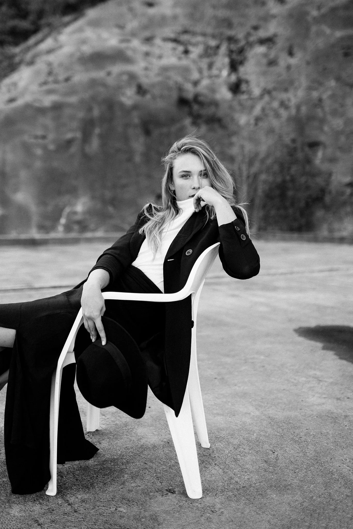 Fashion model poses on white chair.