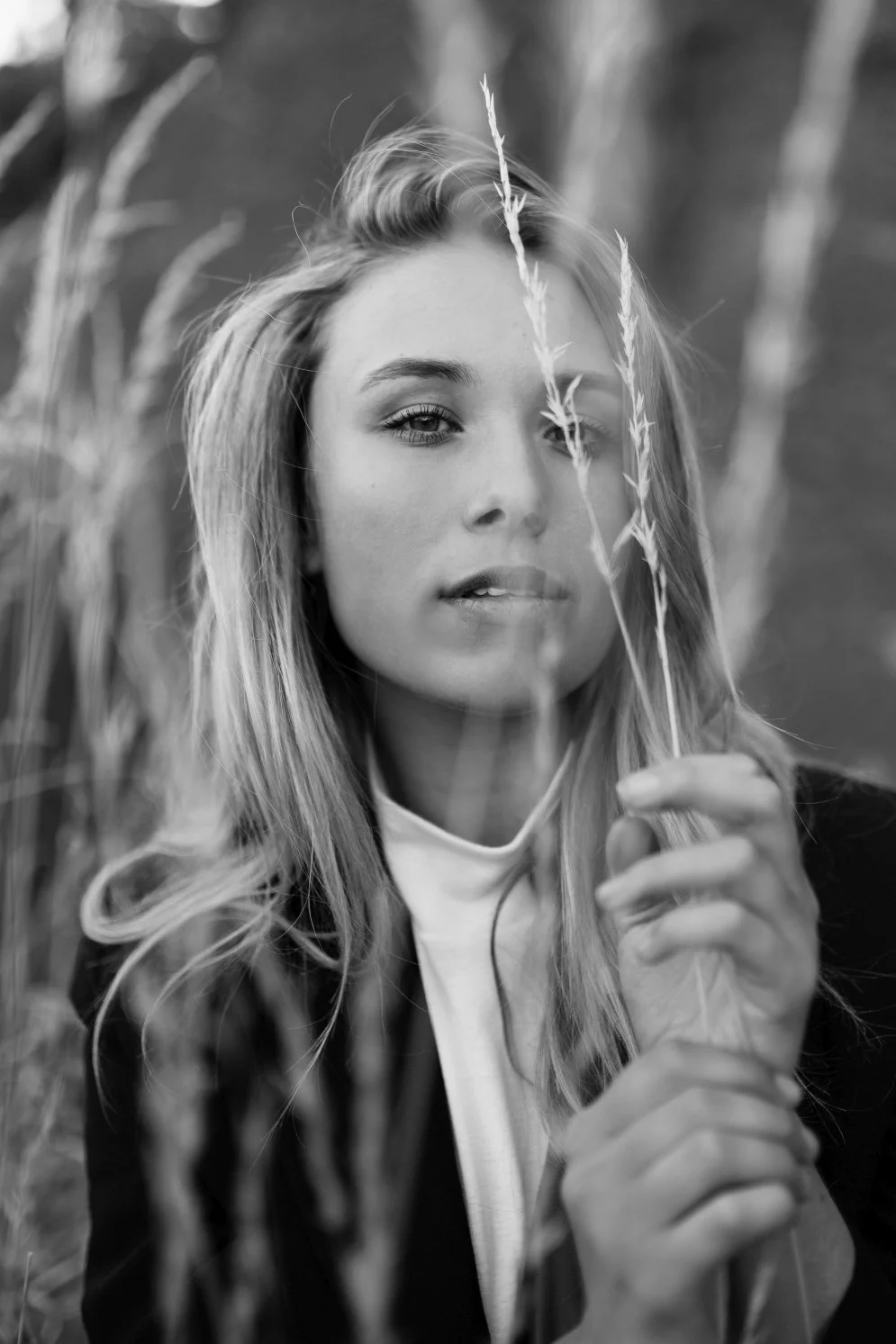 Woman holds dry grass in front of her during model test shoot in Tasmania.