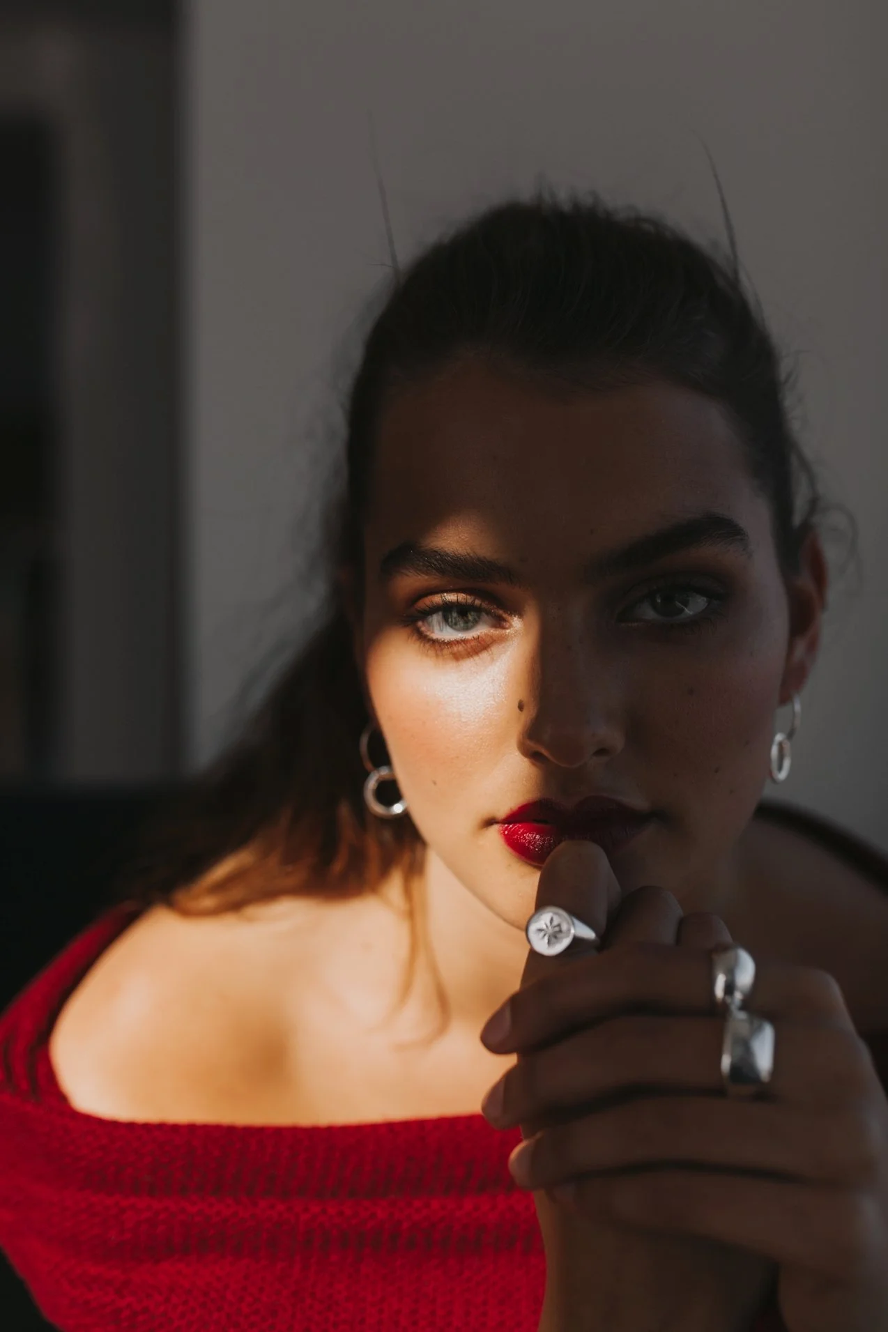 Model stares directly into camera with silver jewellery on.