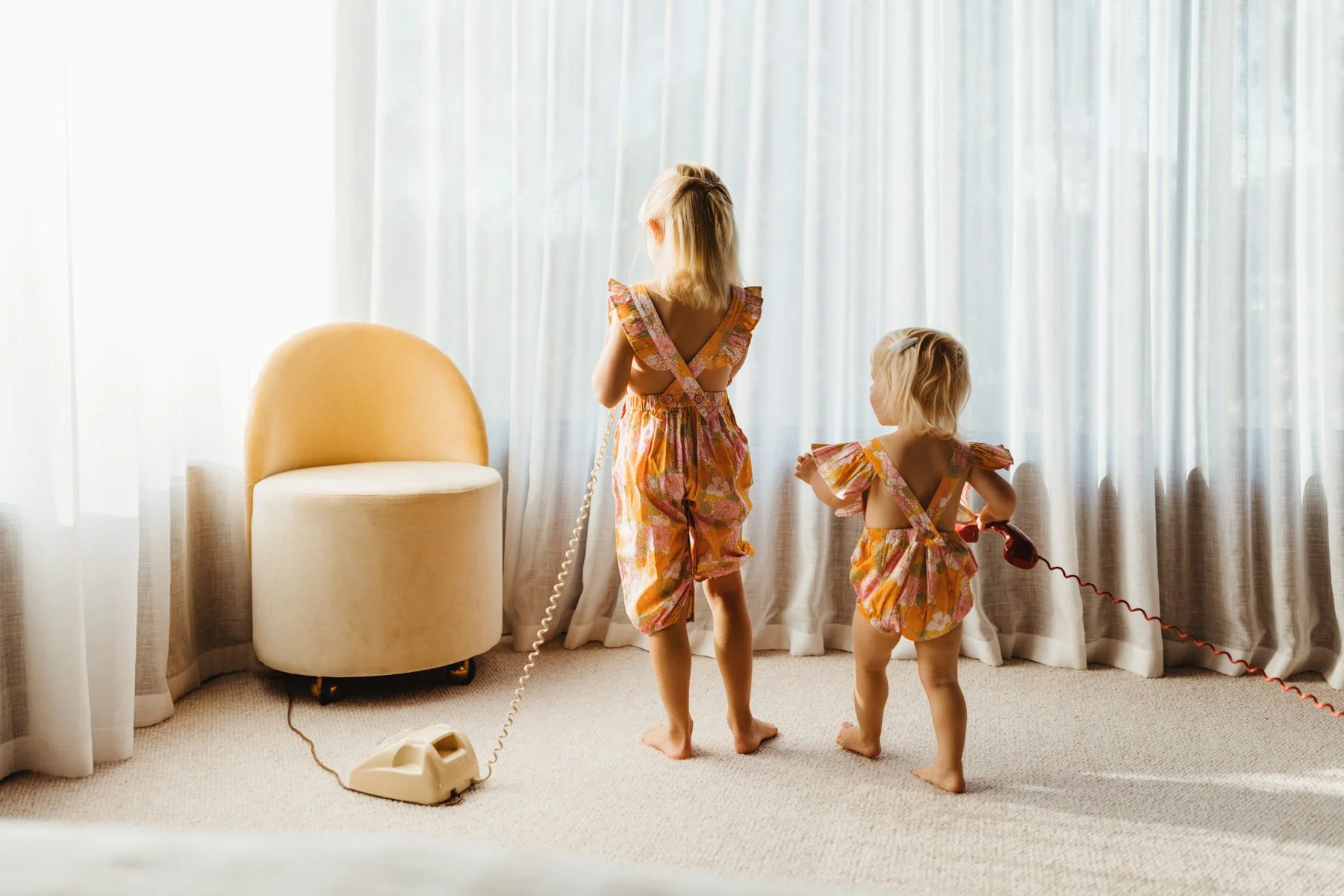 Girls play with vintage telephones in Airbnb in West Hobart.