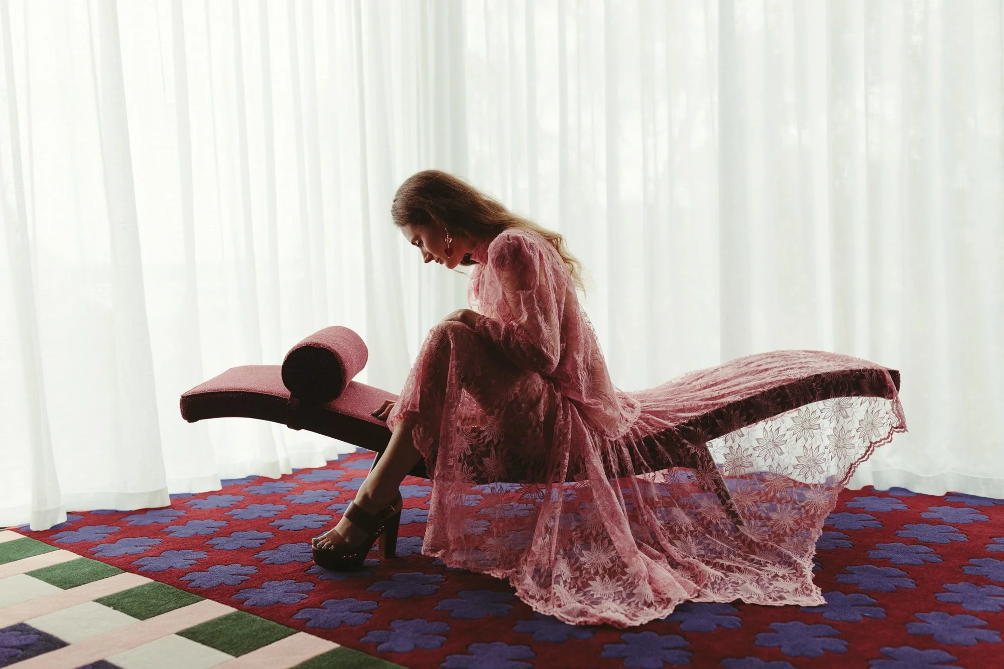 Model wears lace dress on architectural chaise in Hobart photo shoot.