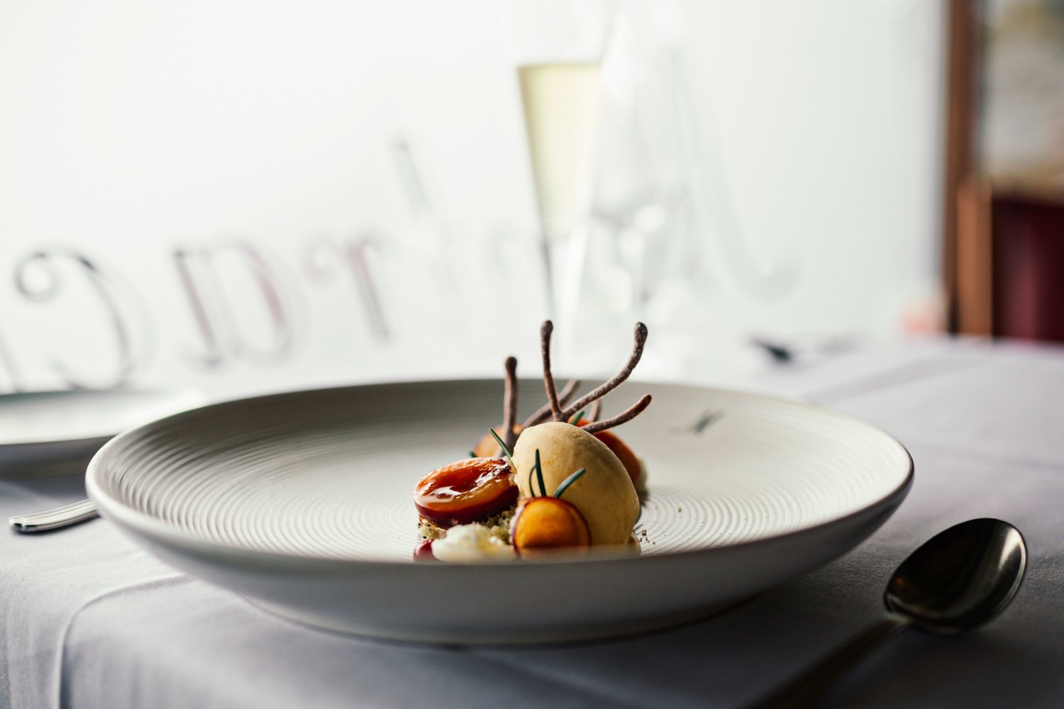 Plate of food on white table cloth in fine dining restaurant.