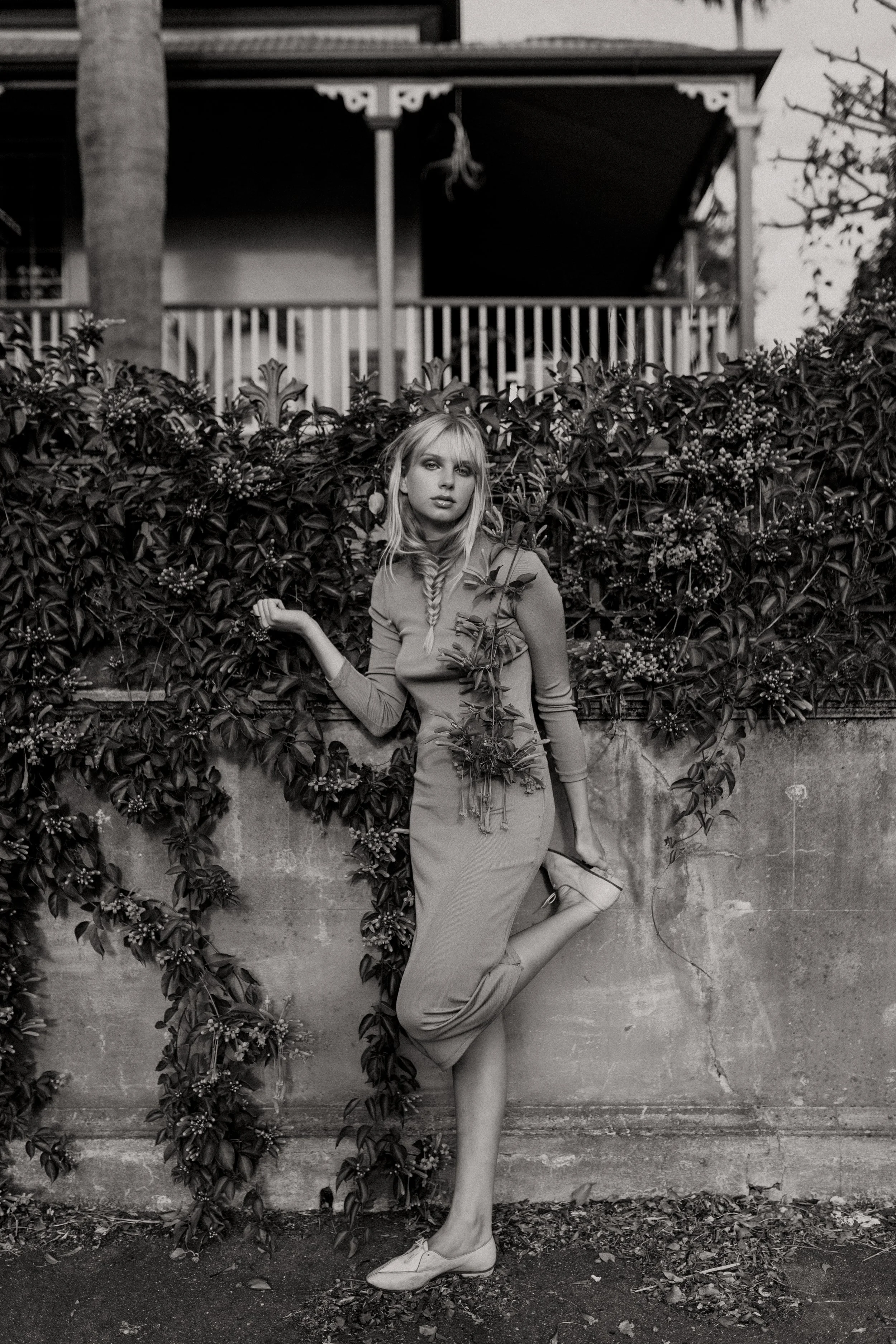 Model stands on one leg as she poses during fashion photo shoot.