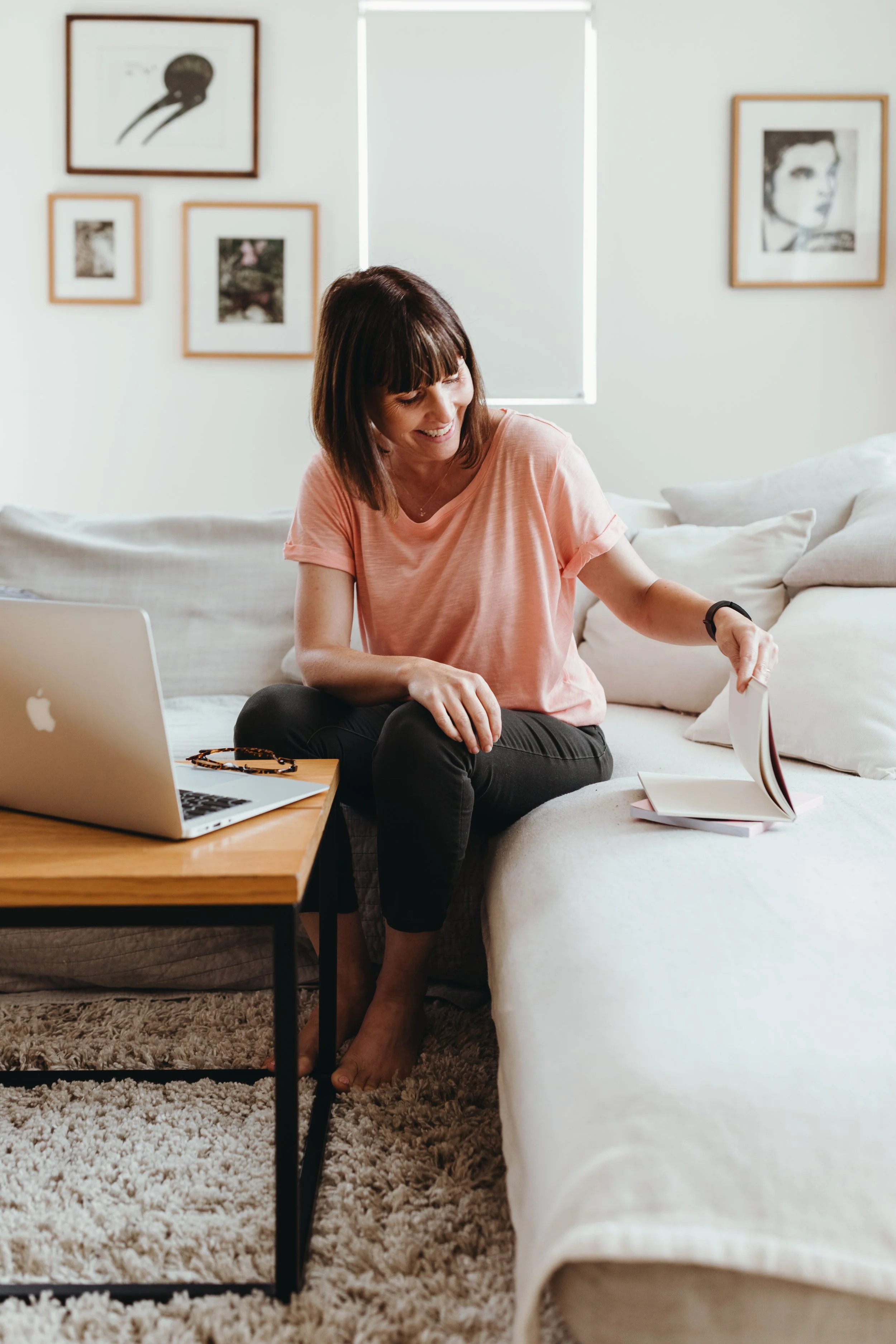 Writer sits and smiles in Hobart home for branding shots.
