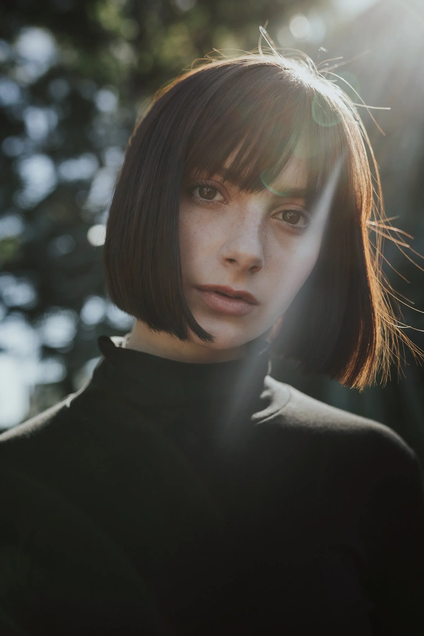 Model poses with sun shining from behind her.