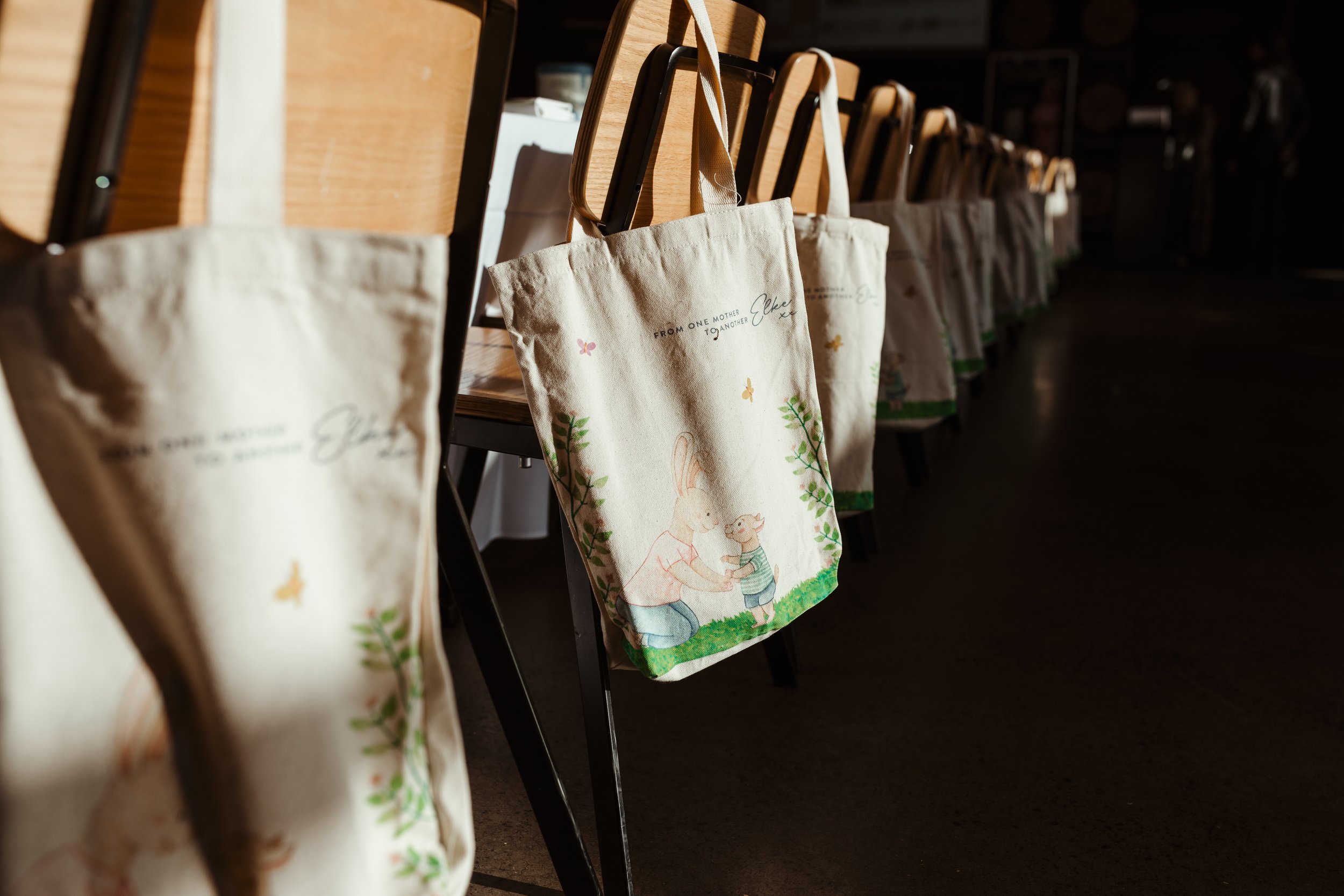 Marketing package bags hang from chairs at event in Hobart, Tasmania.