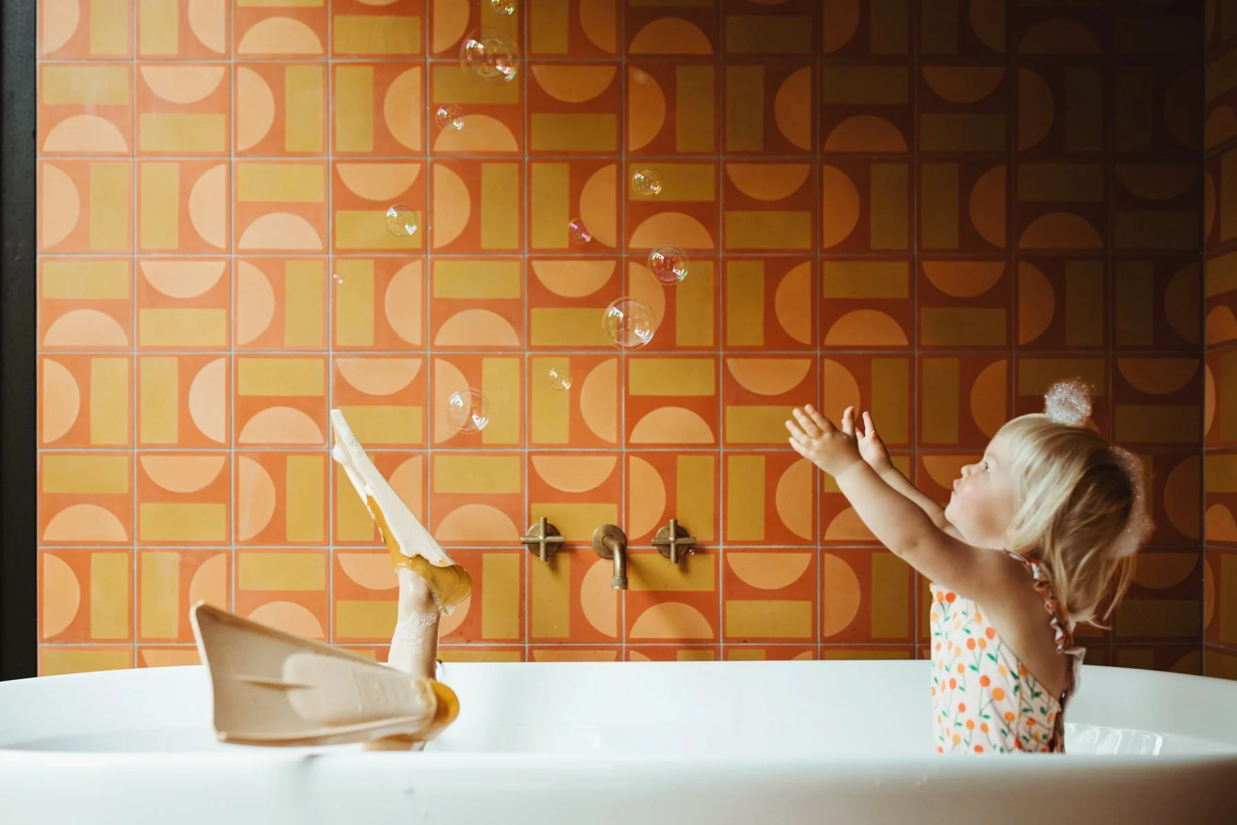 Kids playing in bubble bath with flippers on.
