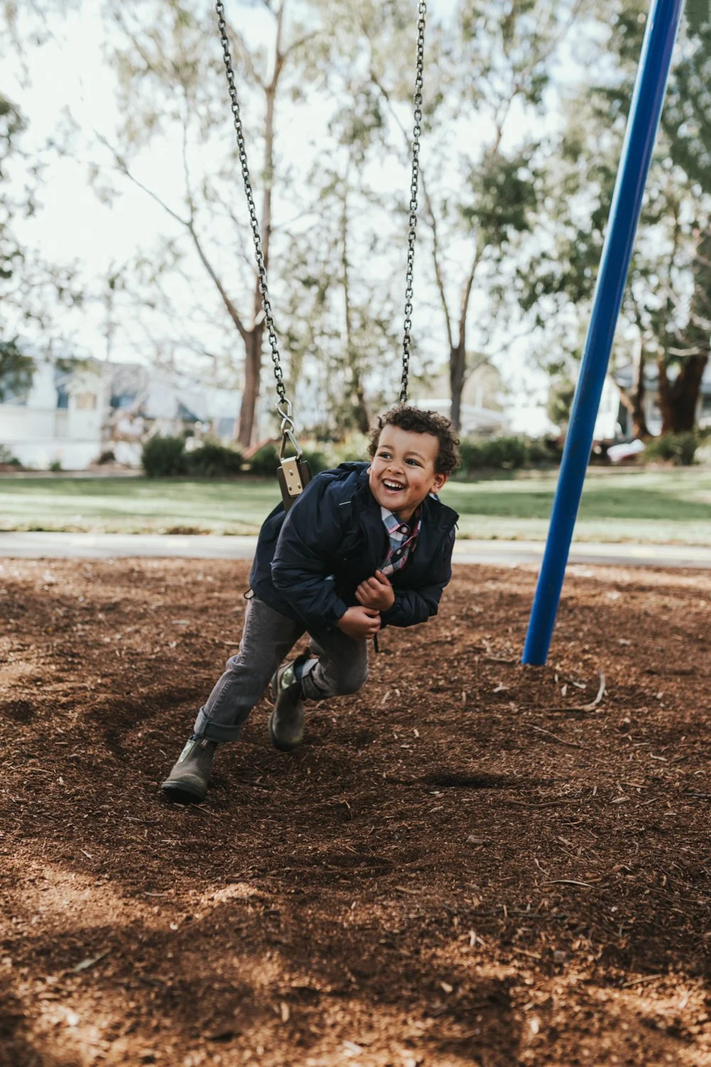 Young boy plays on swing for Blundstone campaign shoot in Hobart.