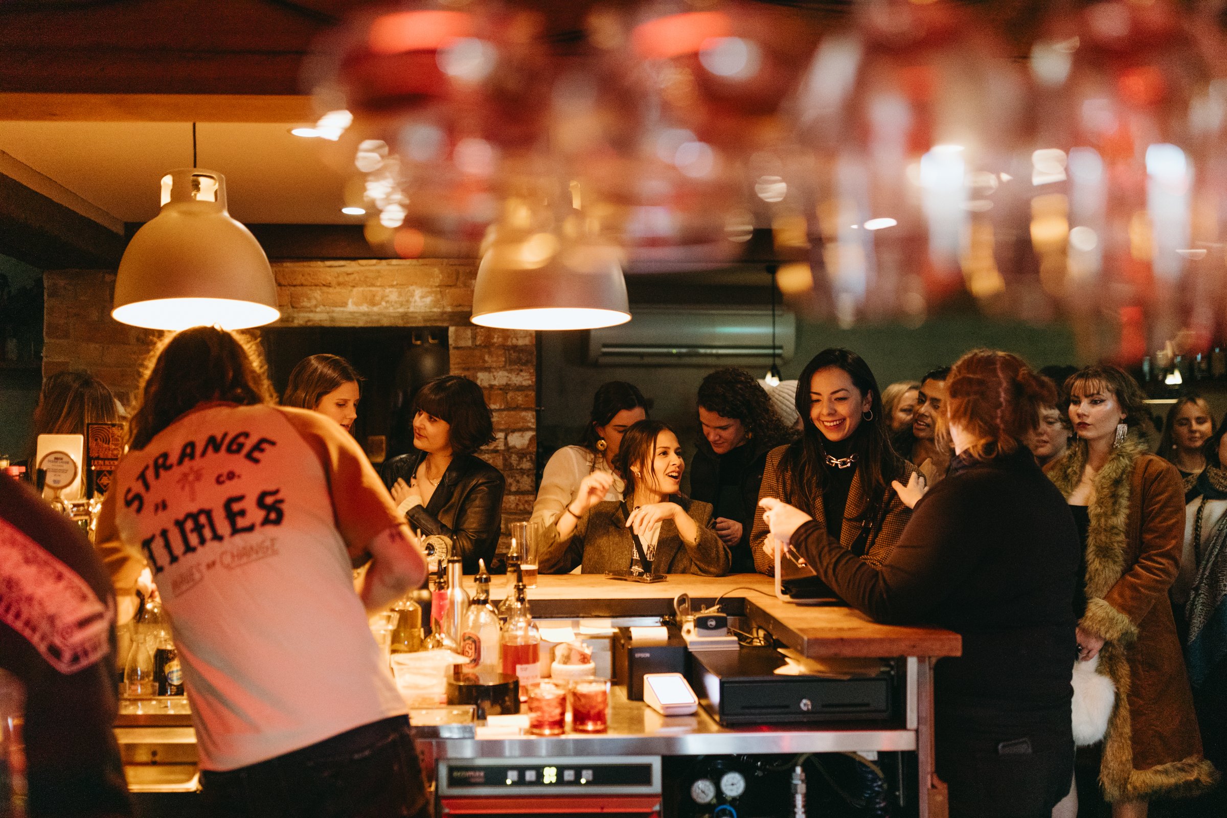 Crowd gathers around bar in Hobart restaurant.