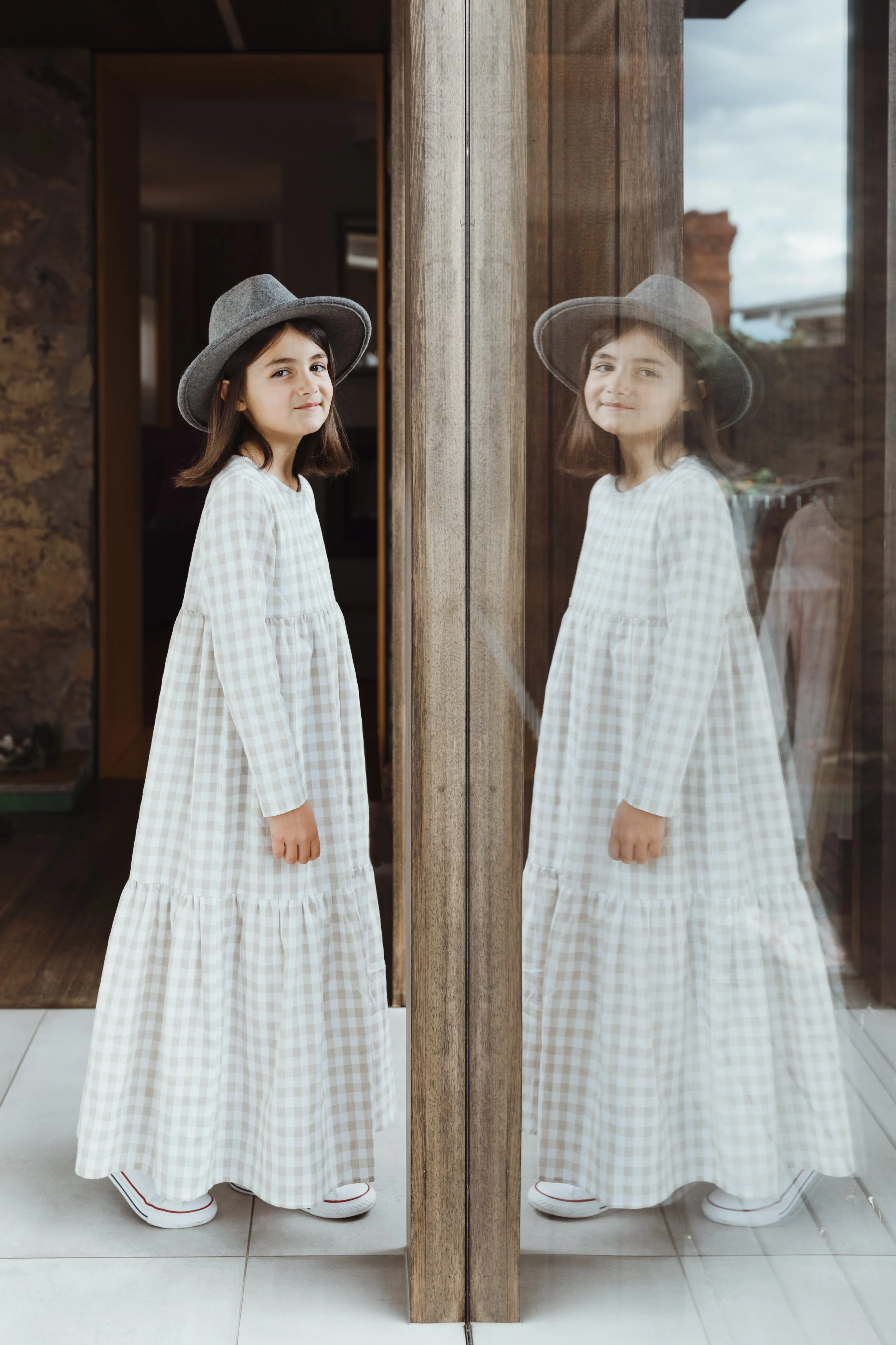 Girl stands in front of window with her reflection during Hobart photo shoot.