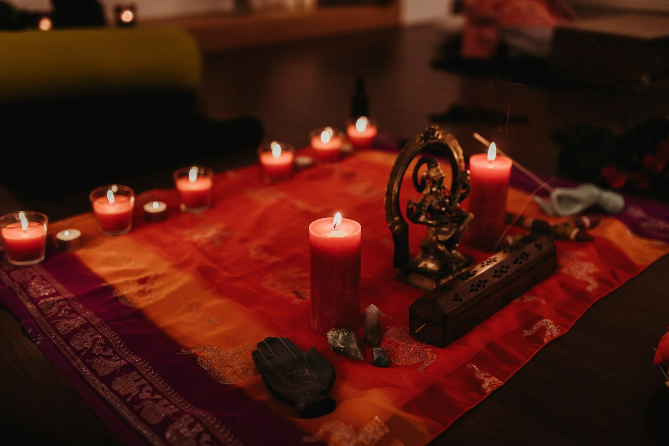 Candles lit on mat for yoga ceremony.