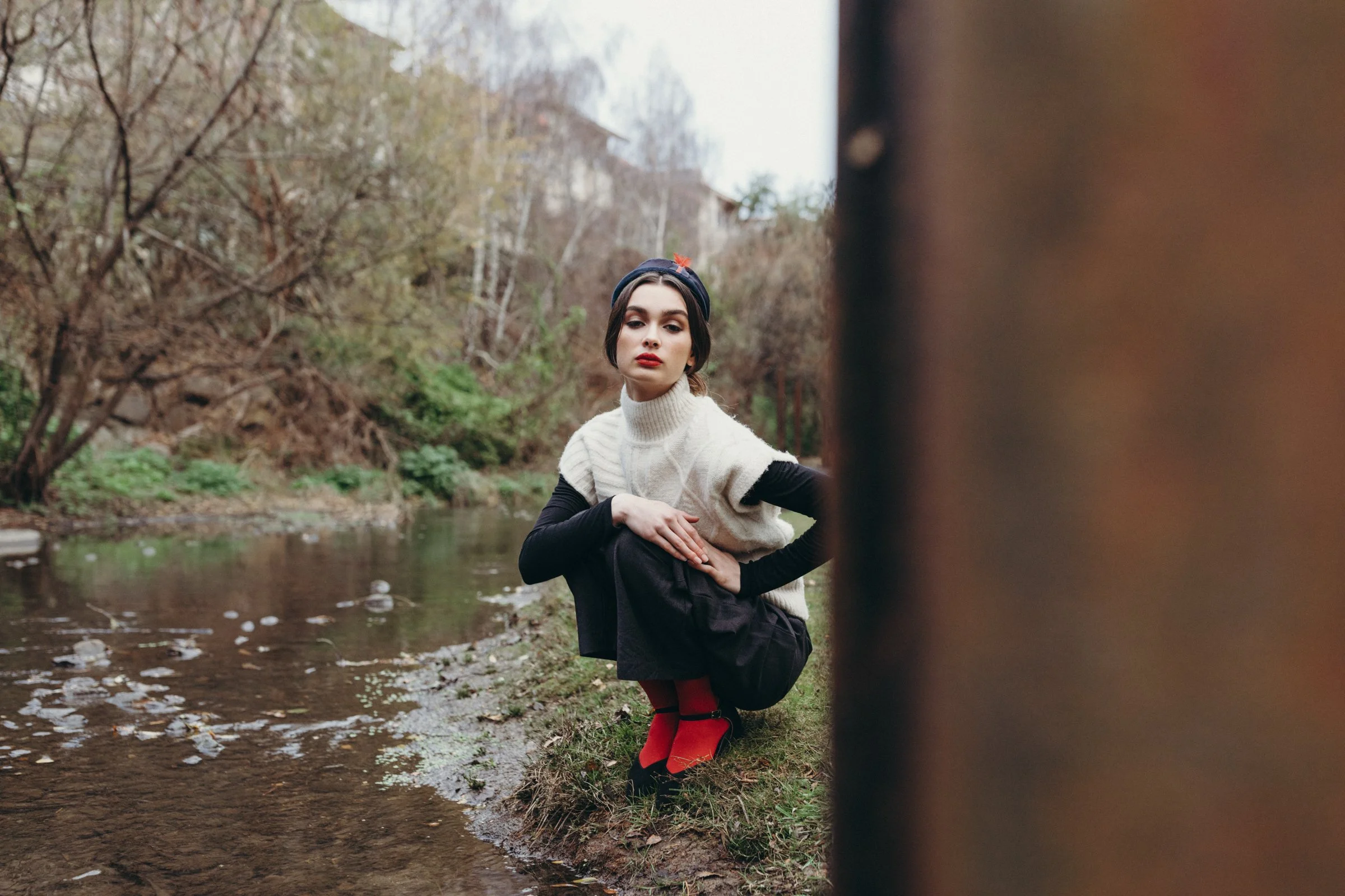 Model poses by rivulet in Hobart fashion photo shoot.