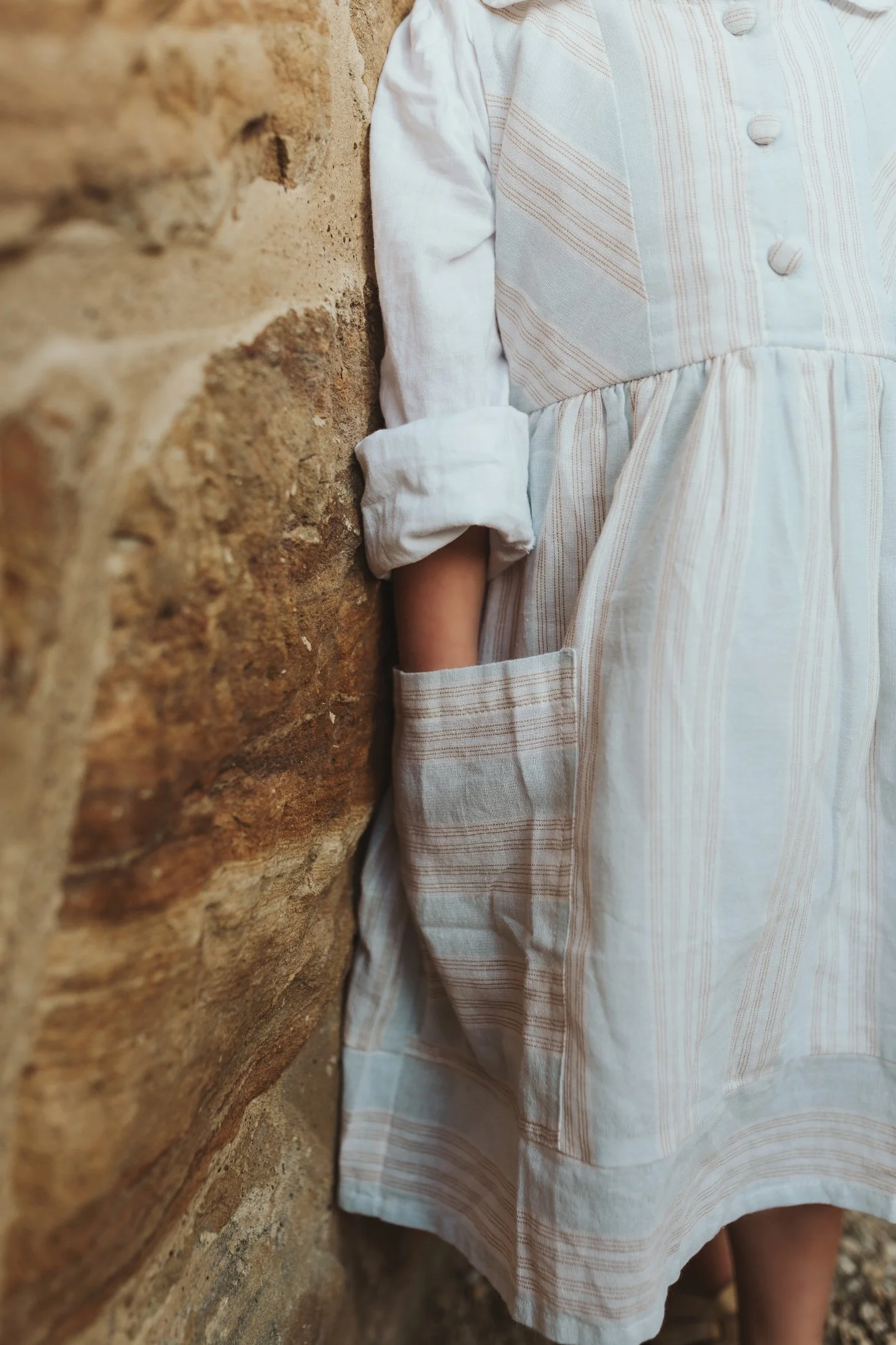 Girl puts something in the pocket of her dress.