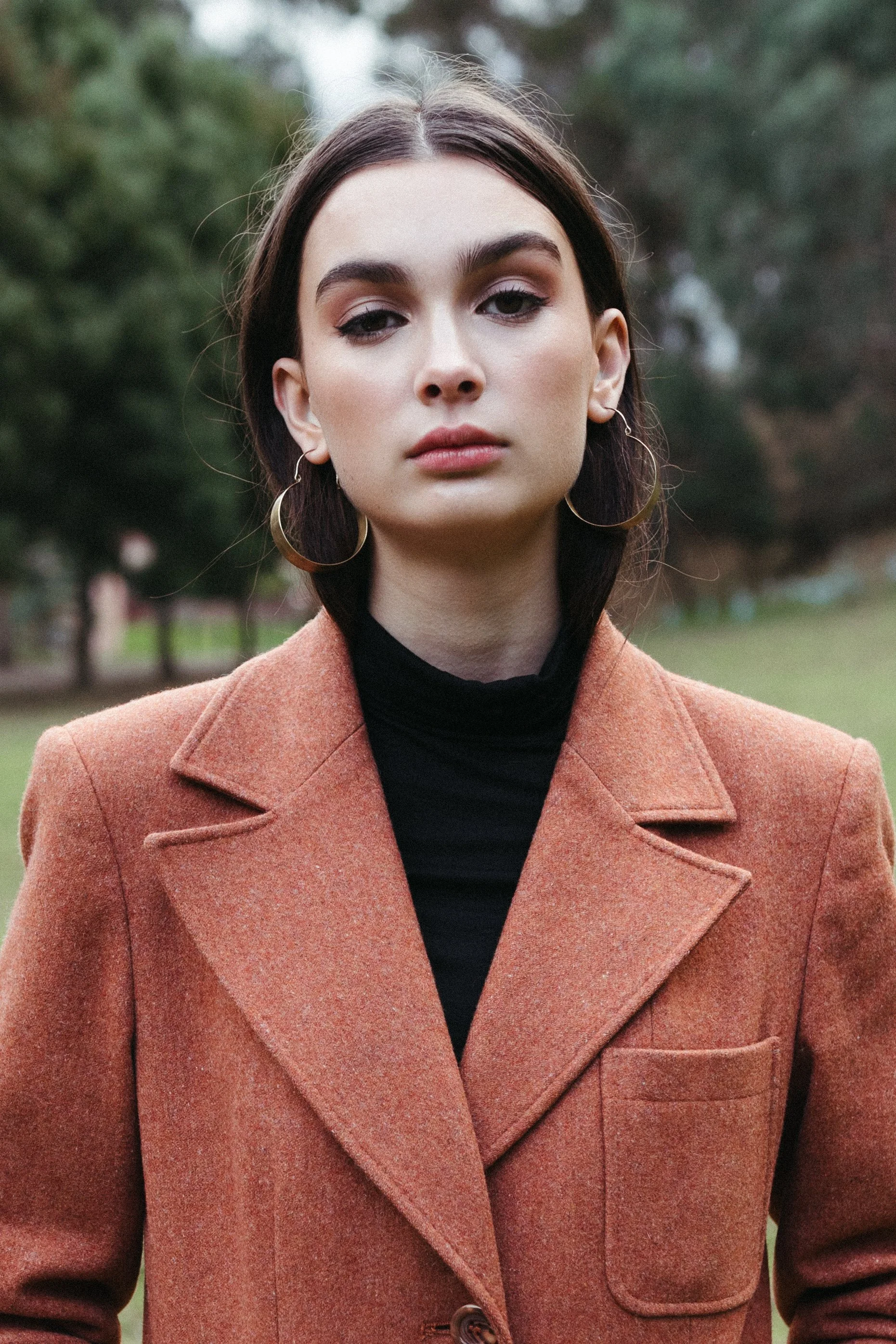 Close up of female model with big gold earrings on.
