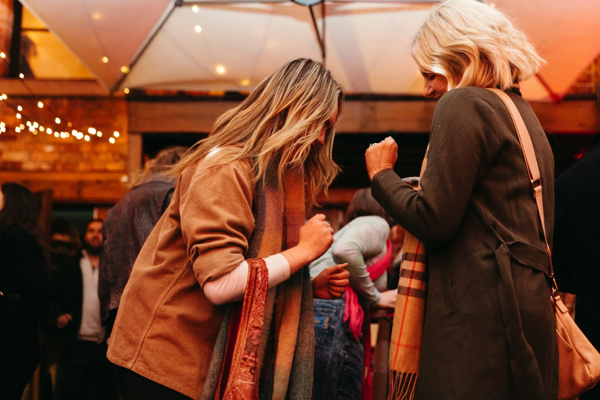 Two women dance in courtyard party event in Hobart, Tasmania.