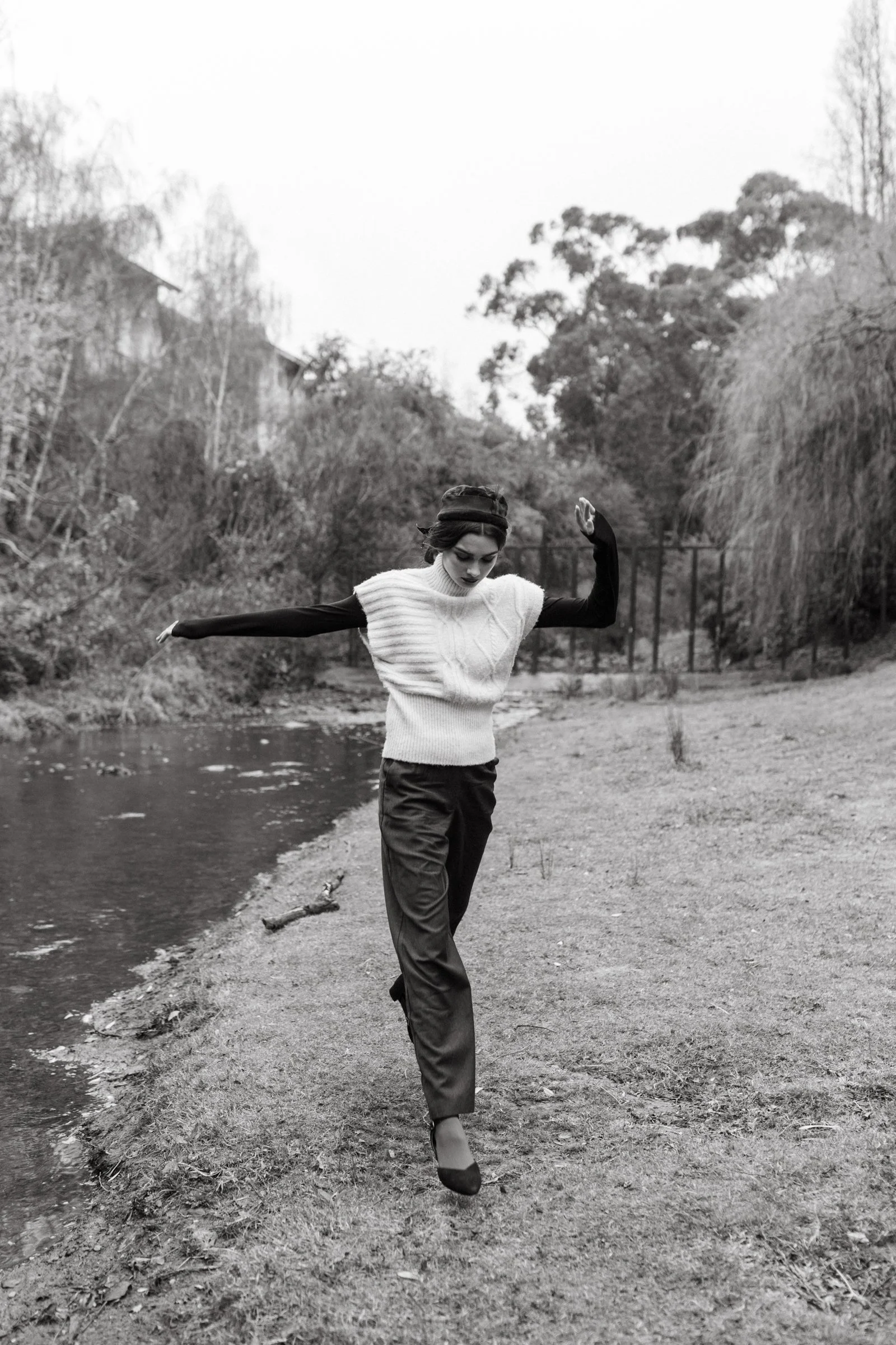 Woman leaps beside creek in Hobart, Tasmania.