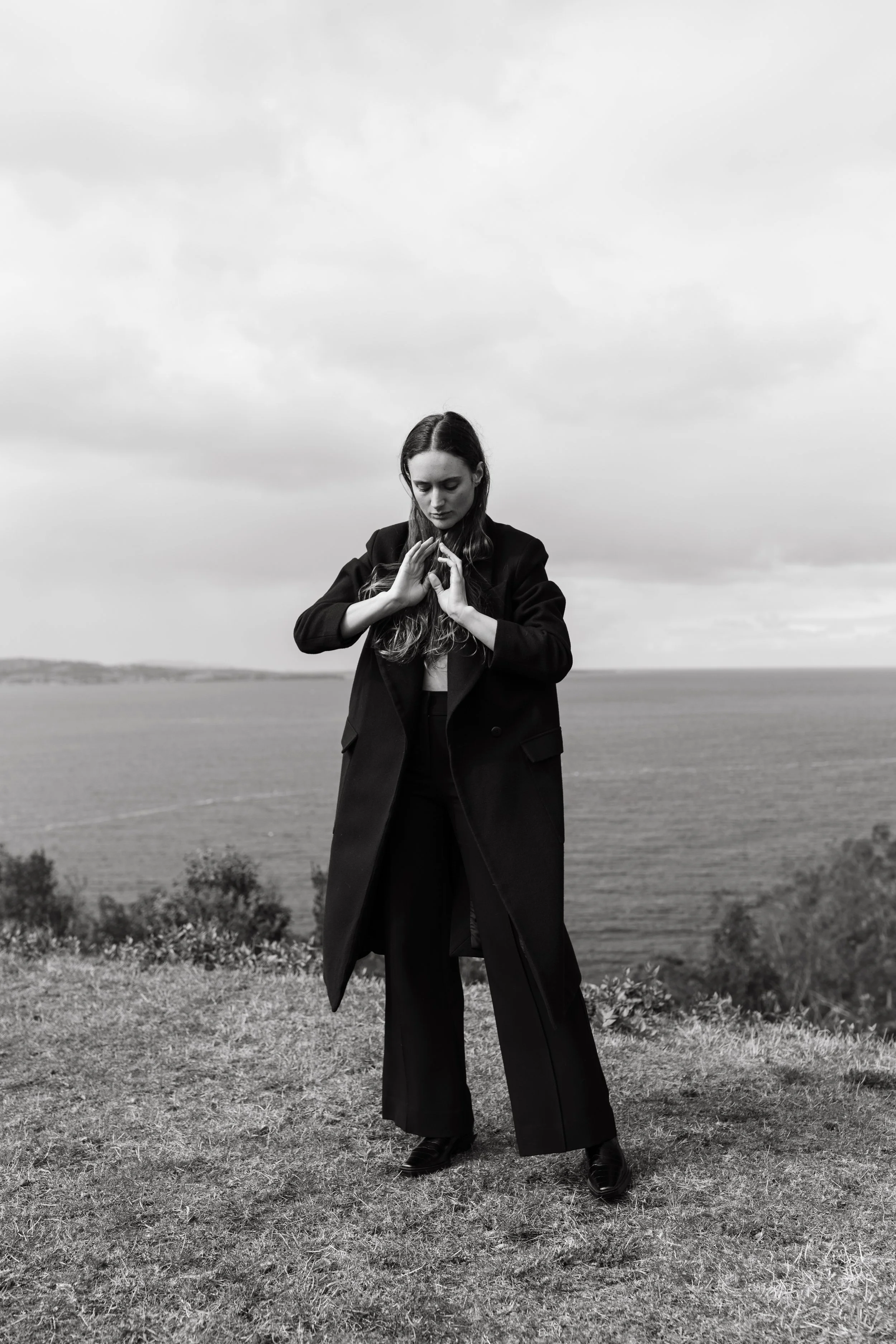 Model poses in Arnsdorf on hill top with ocean in background.
