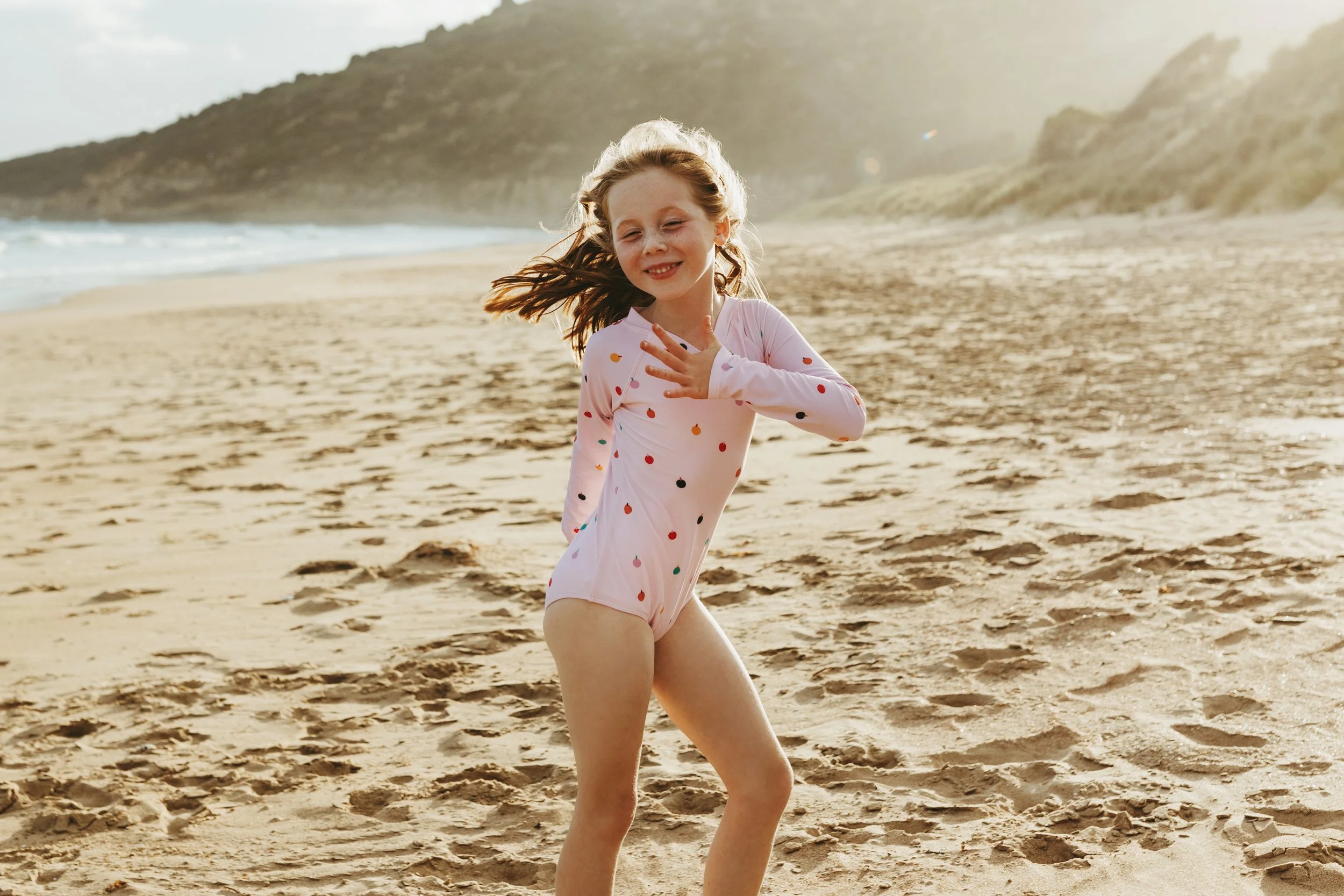 Girl dances in polka dot swimsuit in Hobart.