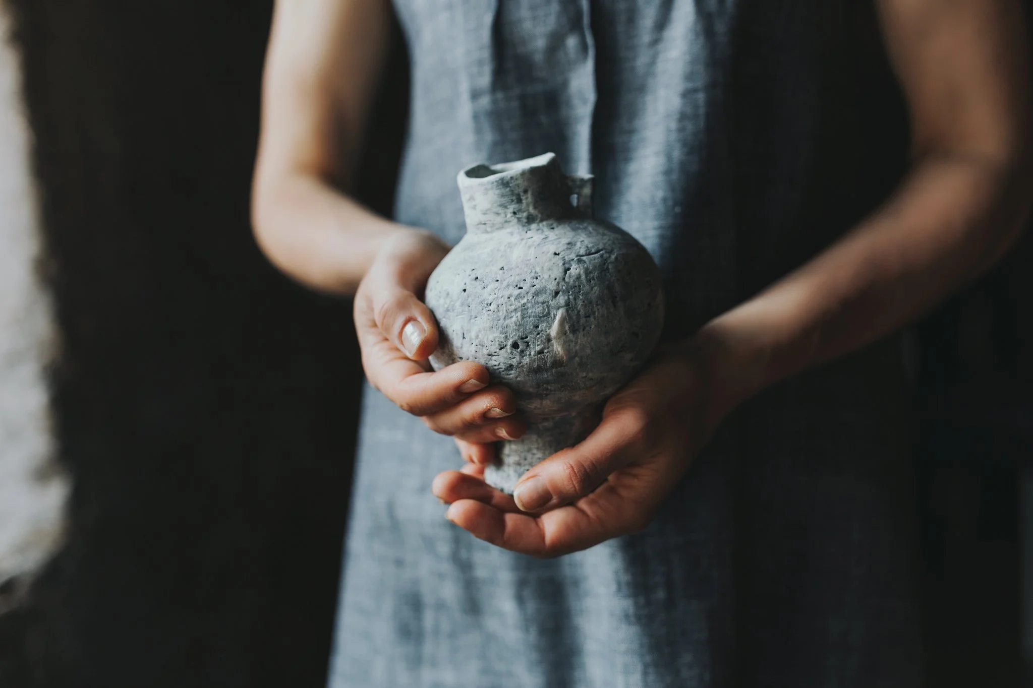 Woman holds pottery for product photography.