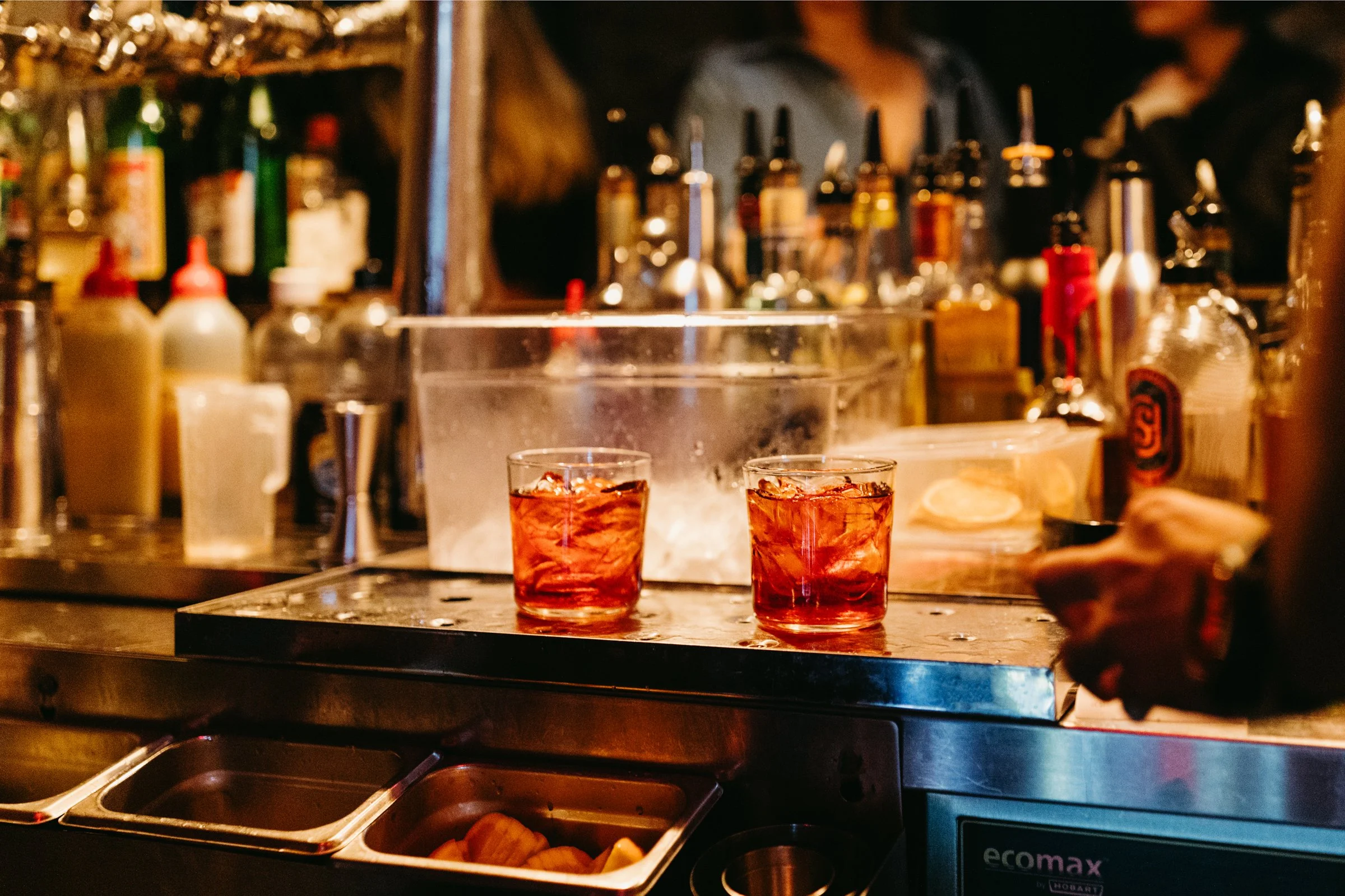 Two icy alcoholic drinks placed behind bar ready for serving.