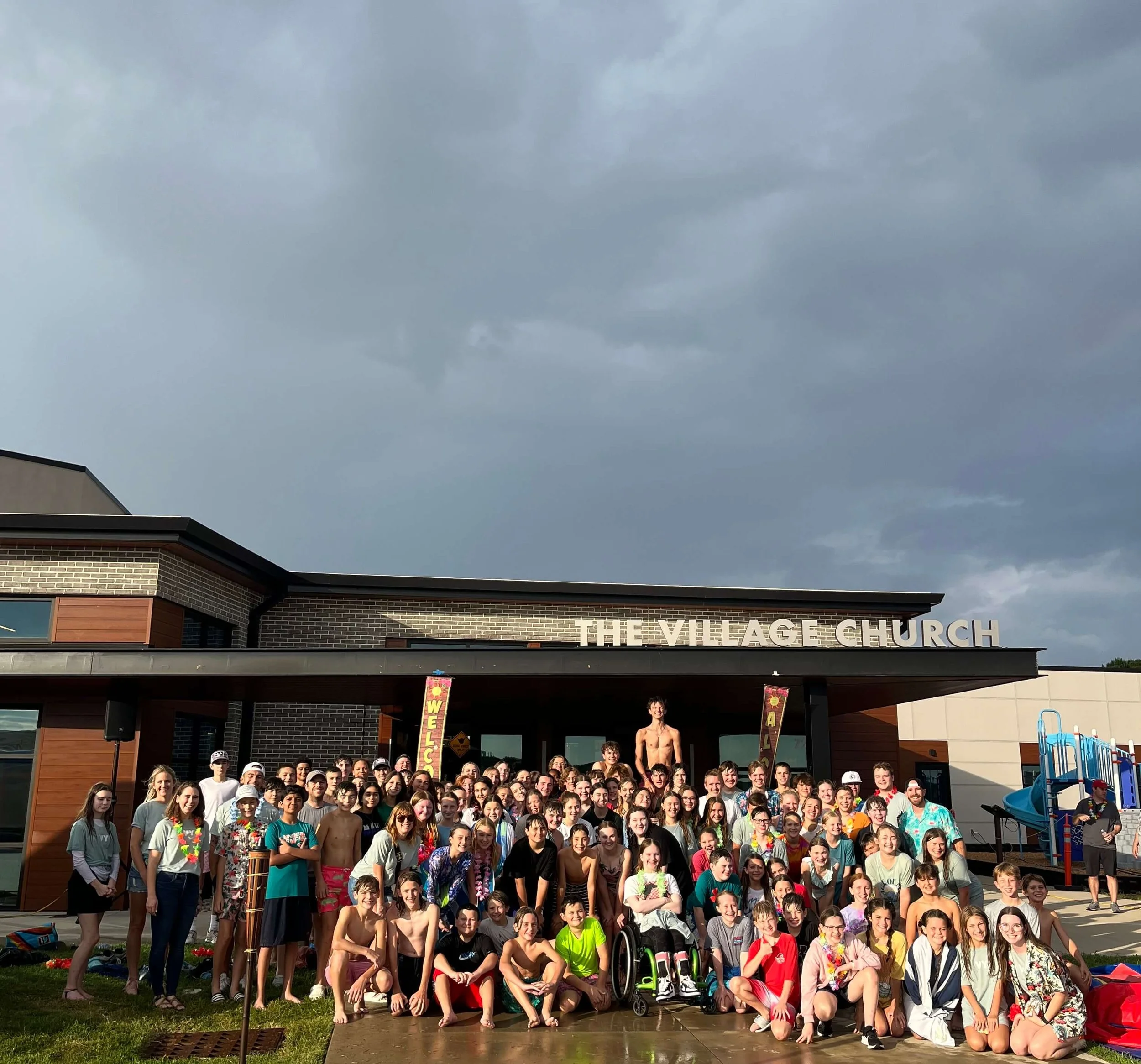 village youth gathered in front of building after summer water activities