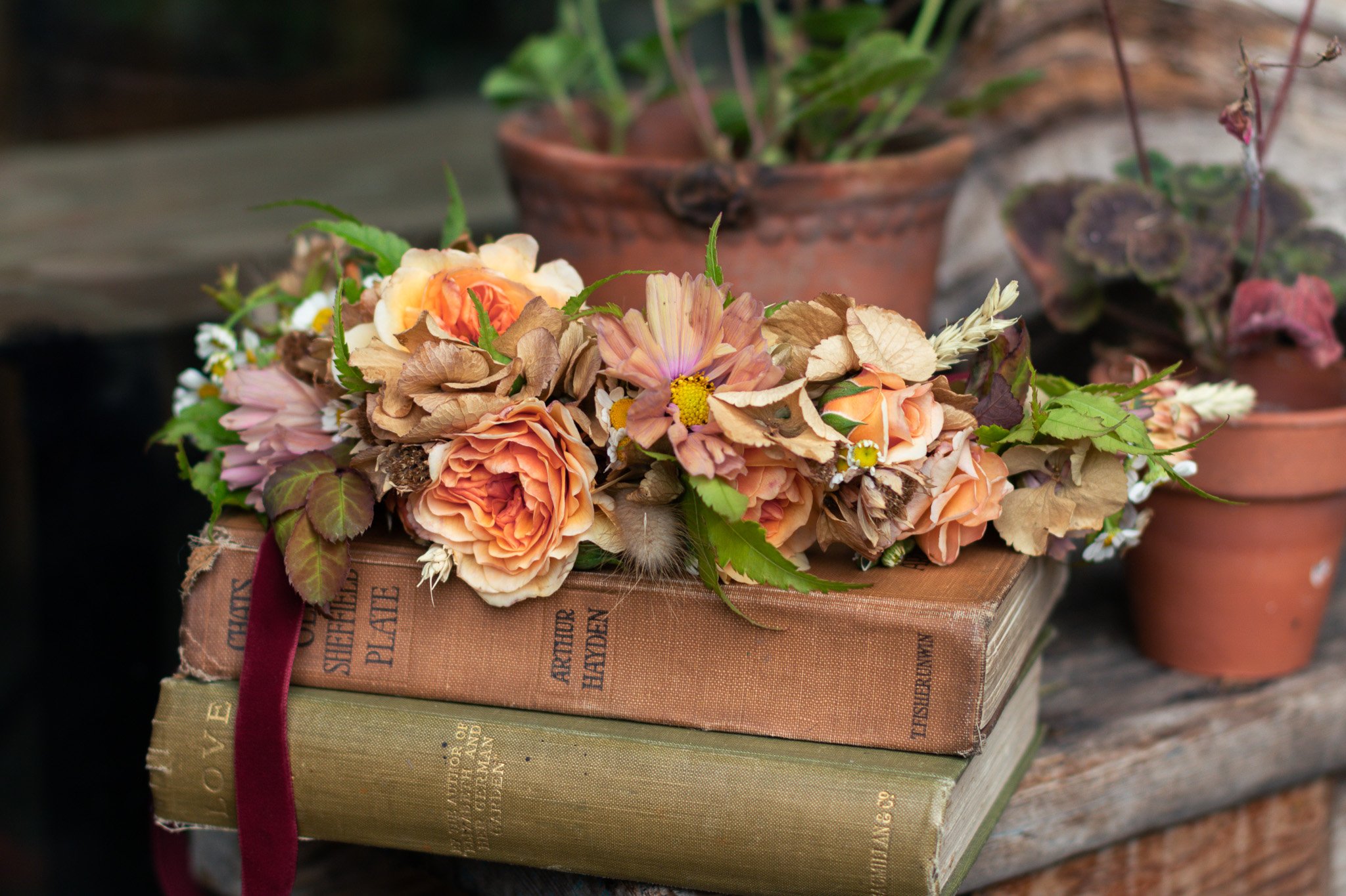 Flower crown of soft peach autumnal colours resting on old books