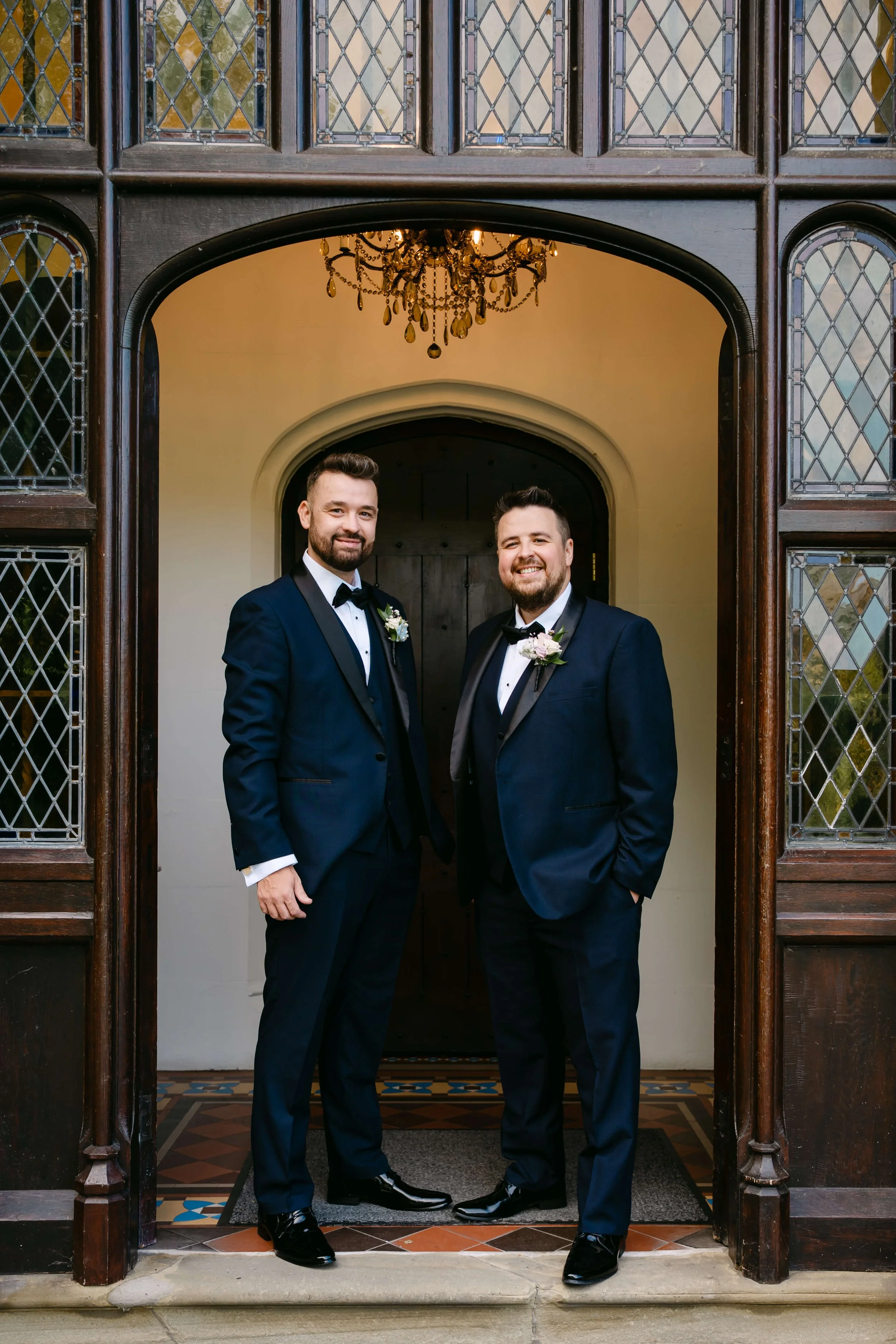 Smart gentlemen in black tie wearing buttonhole florals for a wedding