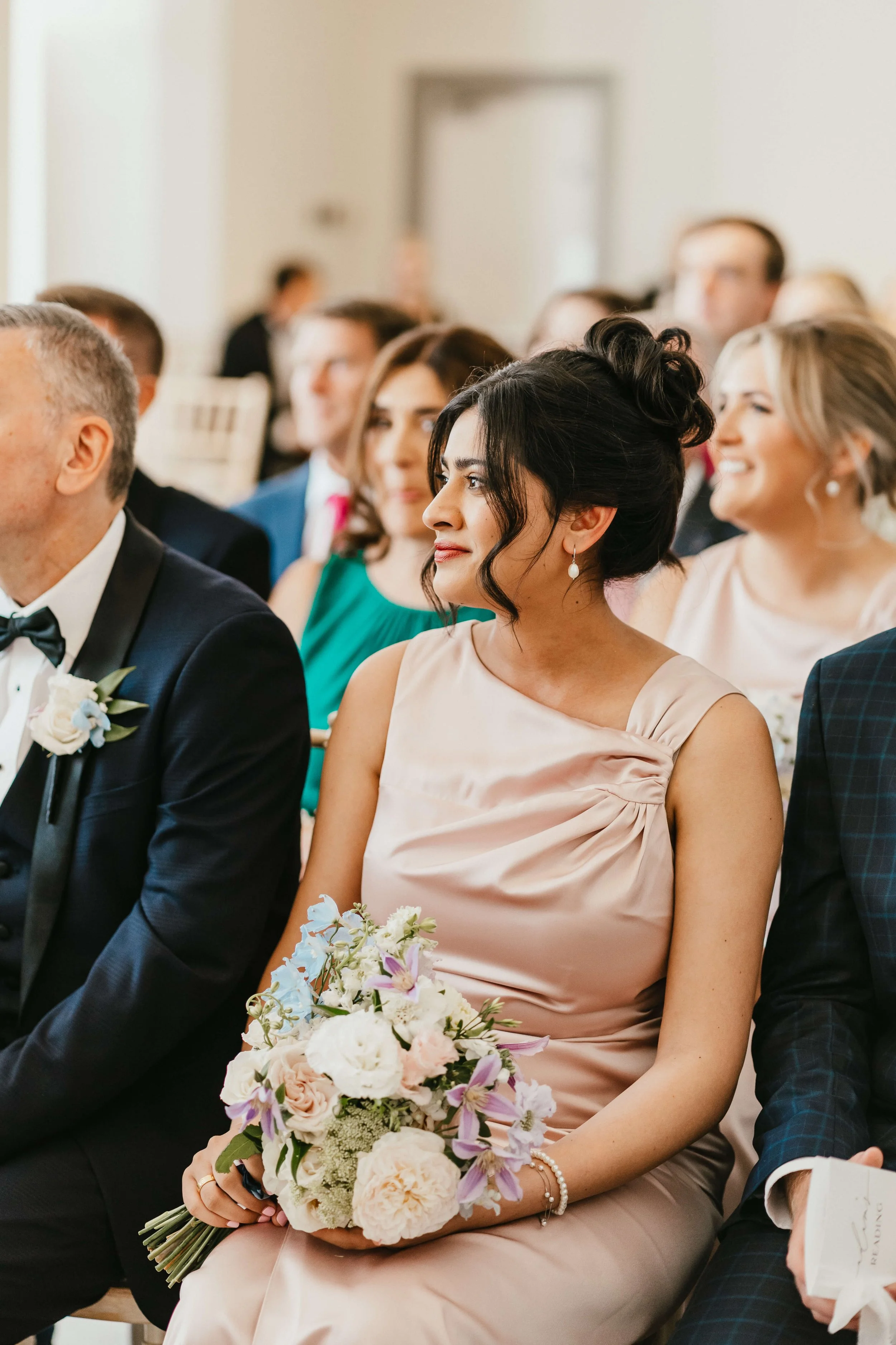 Beautiful bridesmaid with bridesmaid bouquet in blush pink satin dress