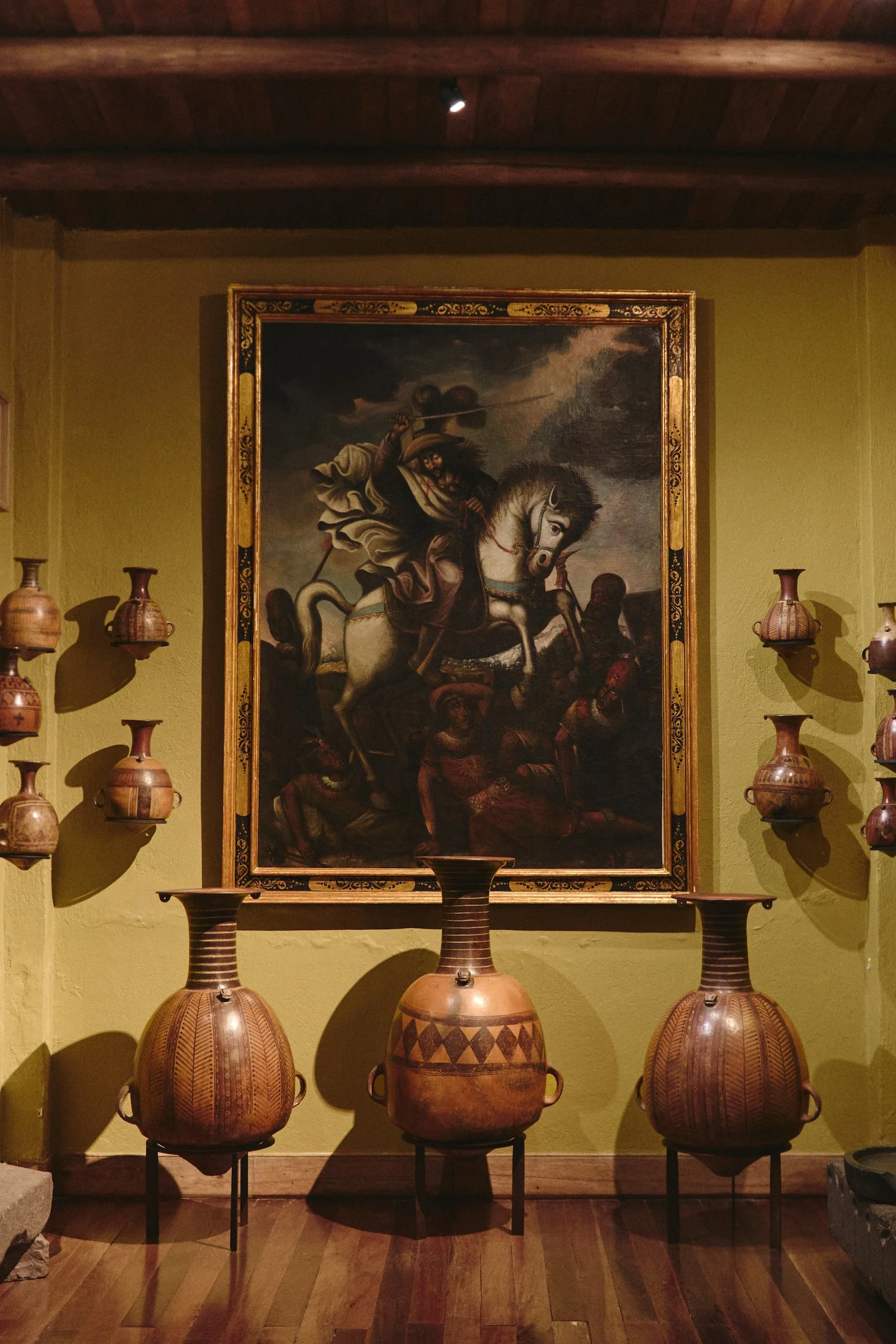 Private gallery at Hacienda Huayoccari in Peru’s Sacred Valley with colonial painting and Andean ceramic vessels, part of a luxury Peru experience by WhereNext Travel.