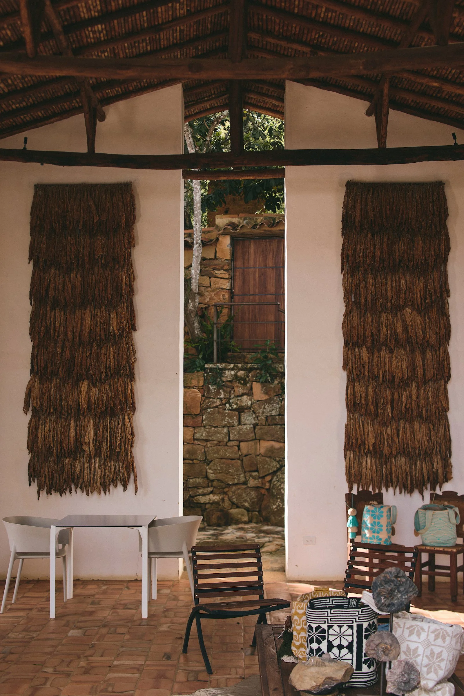 Interior of Terrazul boutique hotel in Barichara, Colombia, featuring a wall decorated with dried tobacco leaves and natural design elements