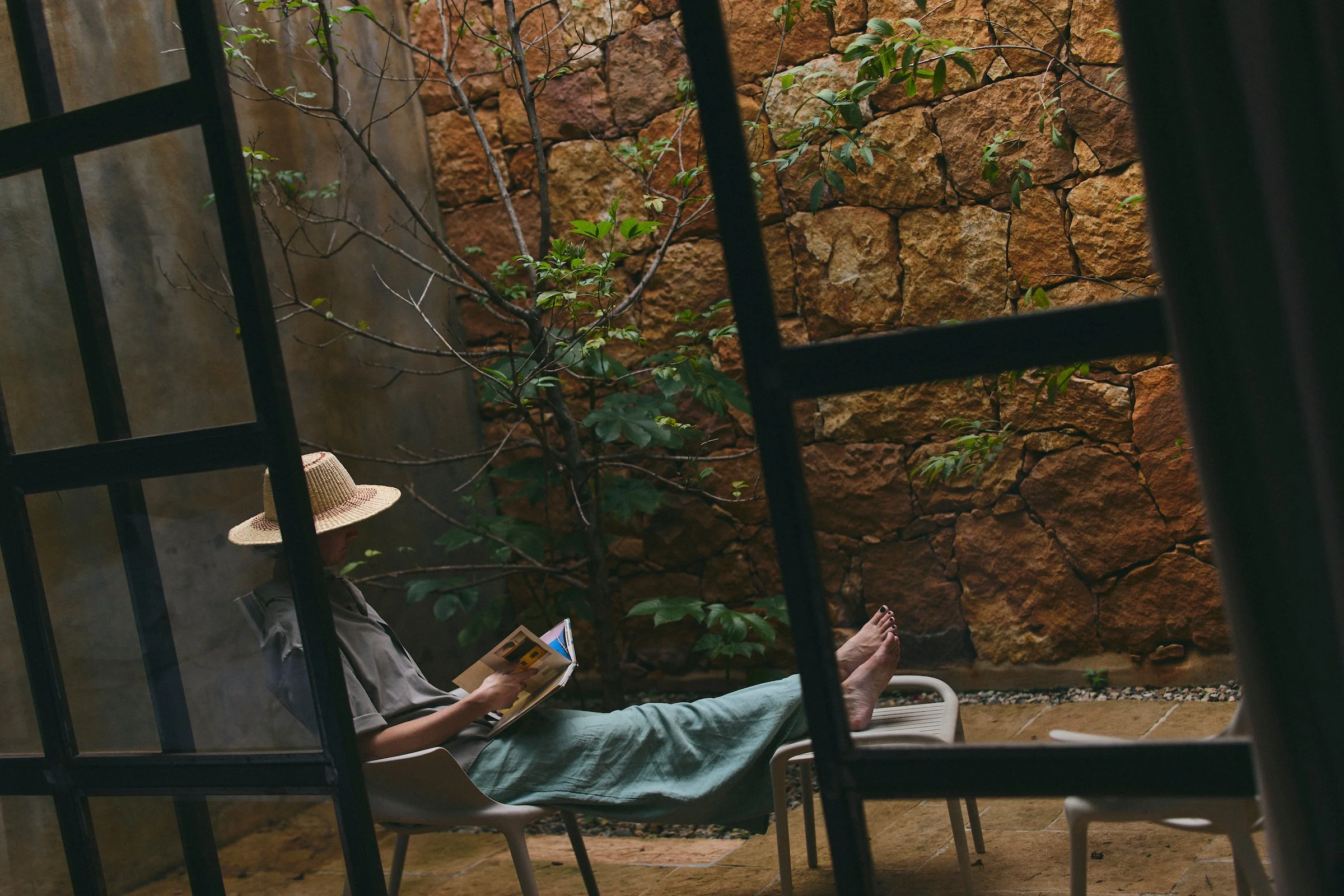 Guest reading a book in the private courtyard of a suite at Terrazul boutique hotel in Barichara, Colombia, surrounded by quiet natural surroundings