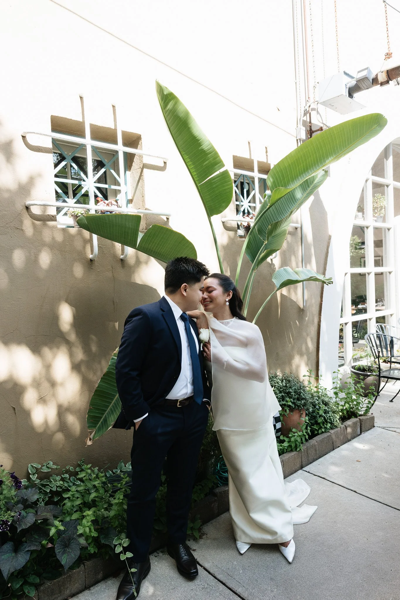 Couple who just eloped in Indianapolis posing in front of a palm plant