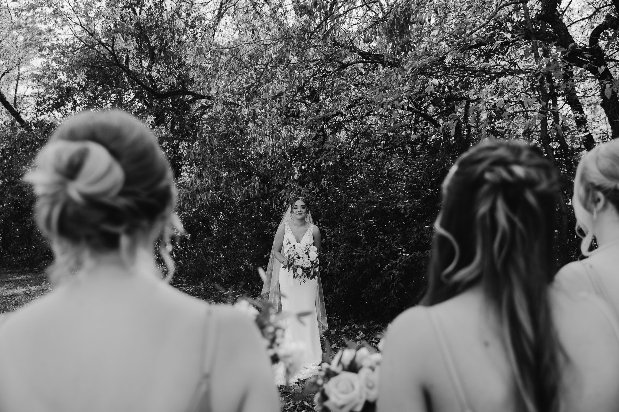 Bride showing off her full wedding look to her bridesmaids