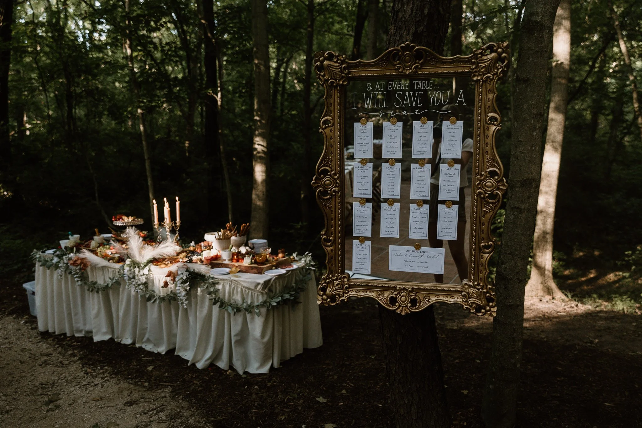Wedding reception set up in the woods with a seating chart and Hors d'oeuvre table